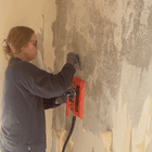 CEO Patricia doing a restauration of a wall for painting