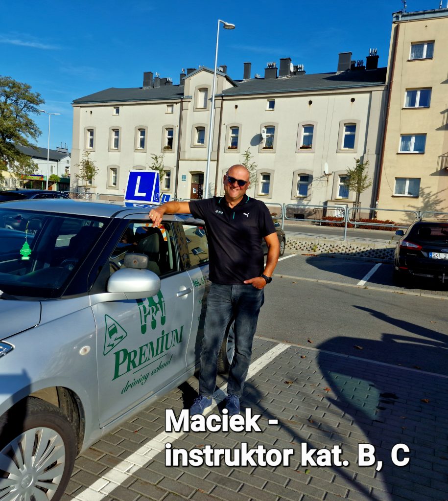 Maciek gotowy do rozpoczęcia lekcji jazdy, uśmiecha się przed samochodem z literą "L".