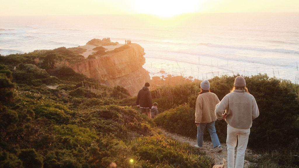 Wild Souls Coliving residents taking a morning walk over the cliffsides to the beach in Ericeira, Portugal