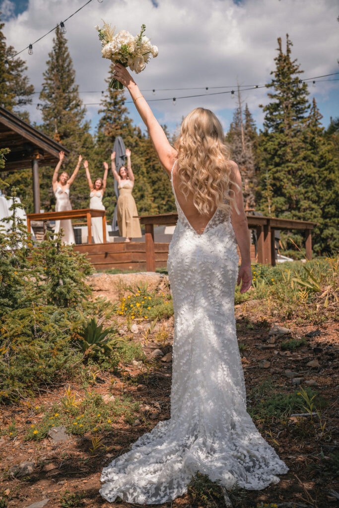 Bride celebrating with bouquet toss moment at Smith Cabin Aspen wedding