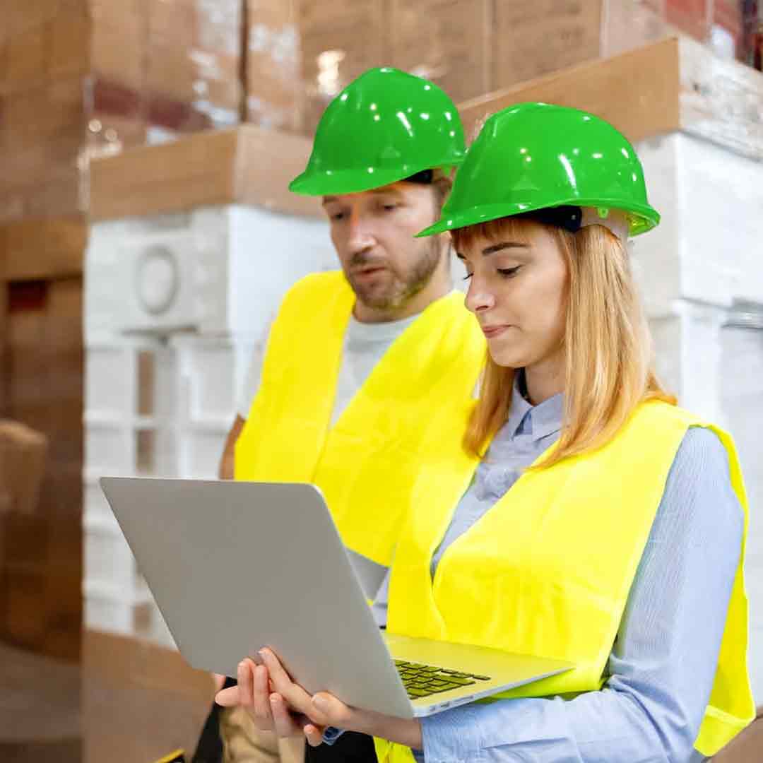 Співробітники у зелених касках проводять аудит ланцюга поставок