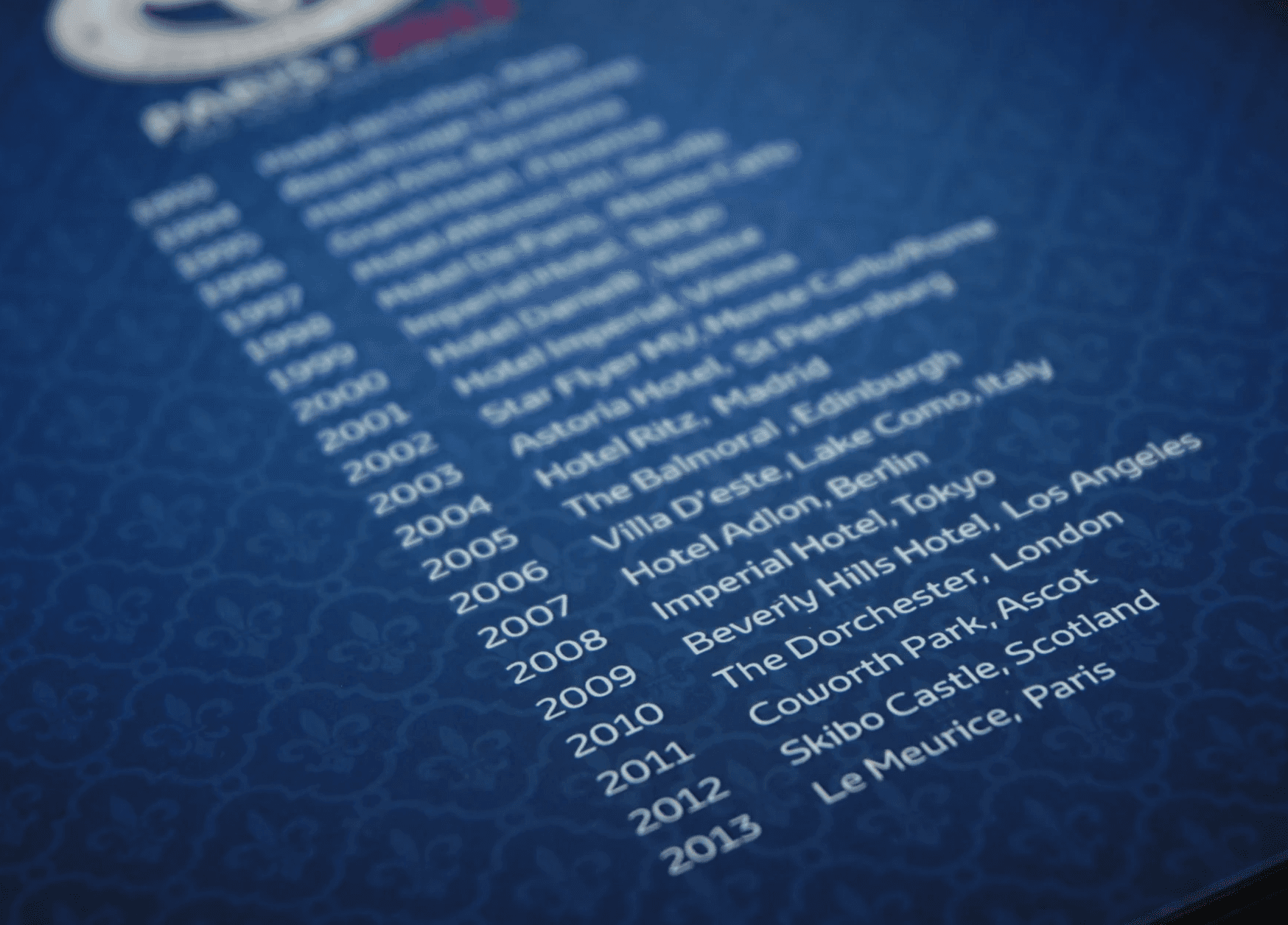 Close-up of a printed event programme featuring a timeline of past events and venues