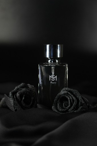 a bottle of perfume sitting on top of a bed