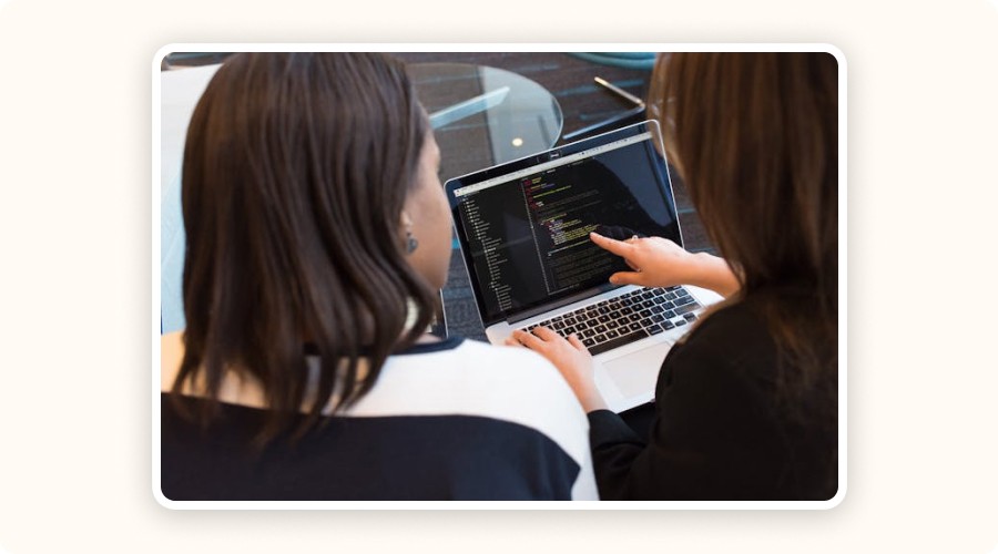 Two marketers reviewing SEO performance data on a screen — showing SEO evolution over time.