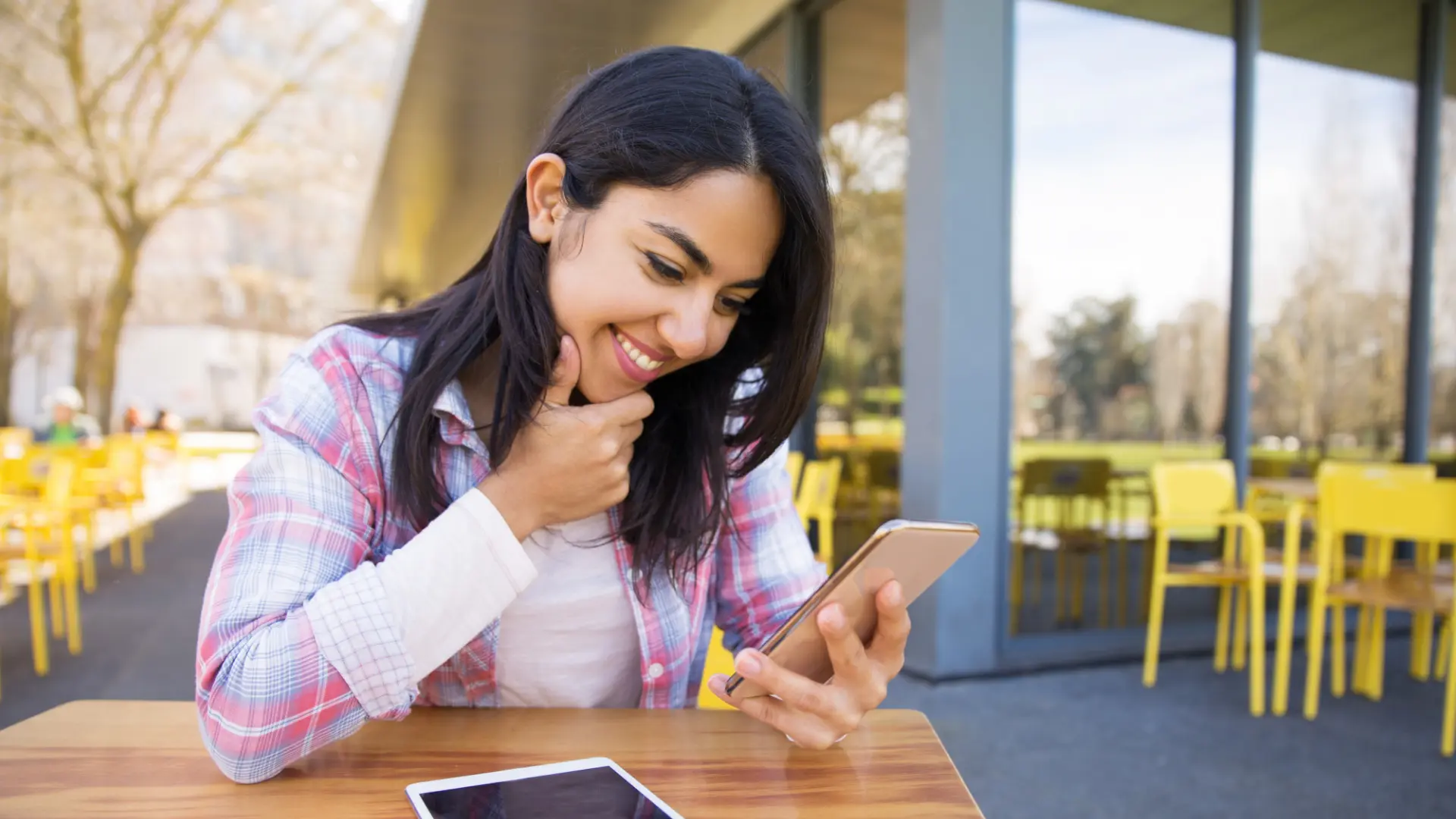 A Gen Z job seeker smiles as she finds career advice and job leads on her smartphone via TikTok.