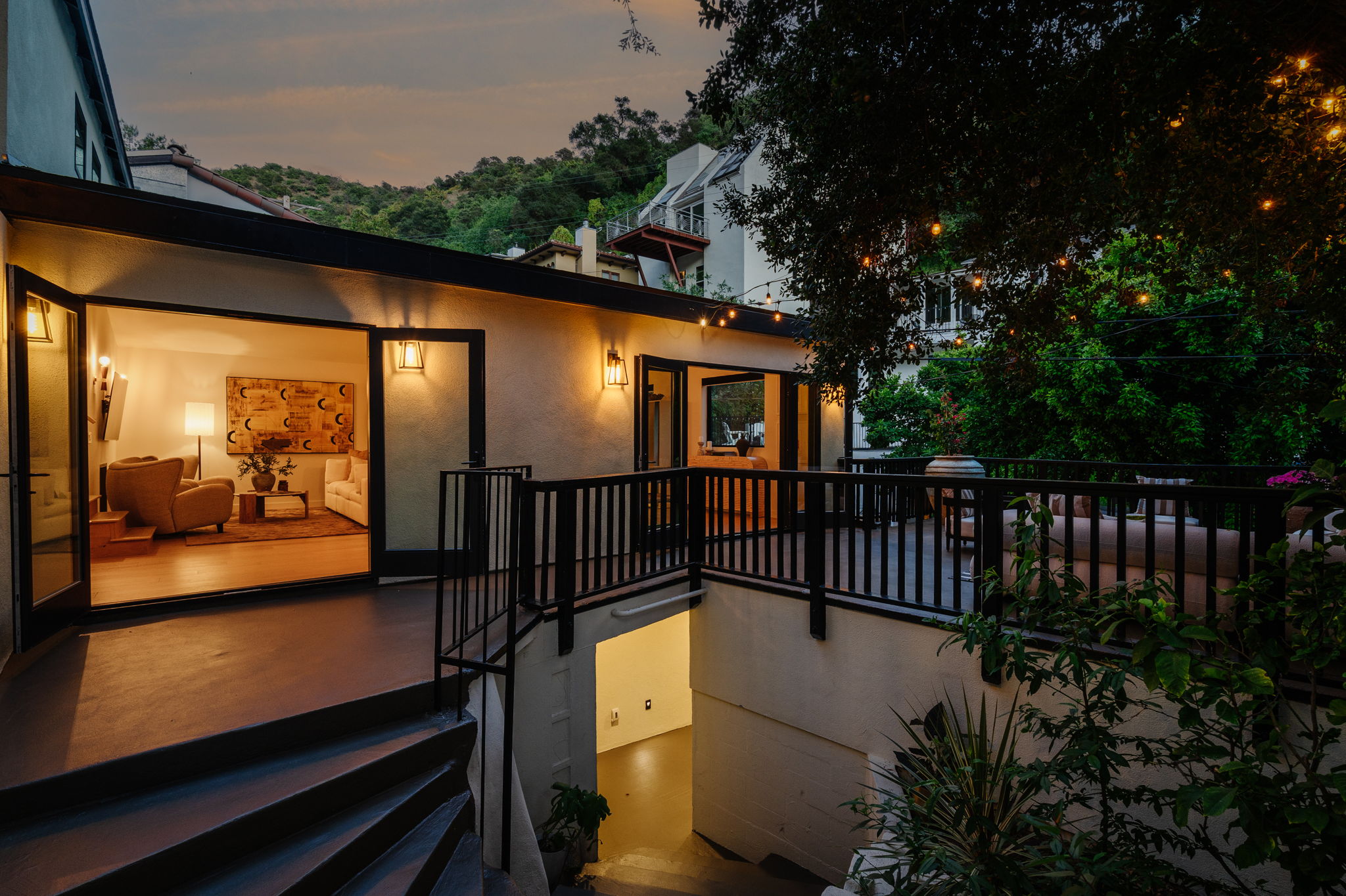 Modern house with elevated glass balcony and hillside view