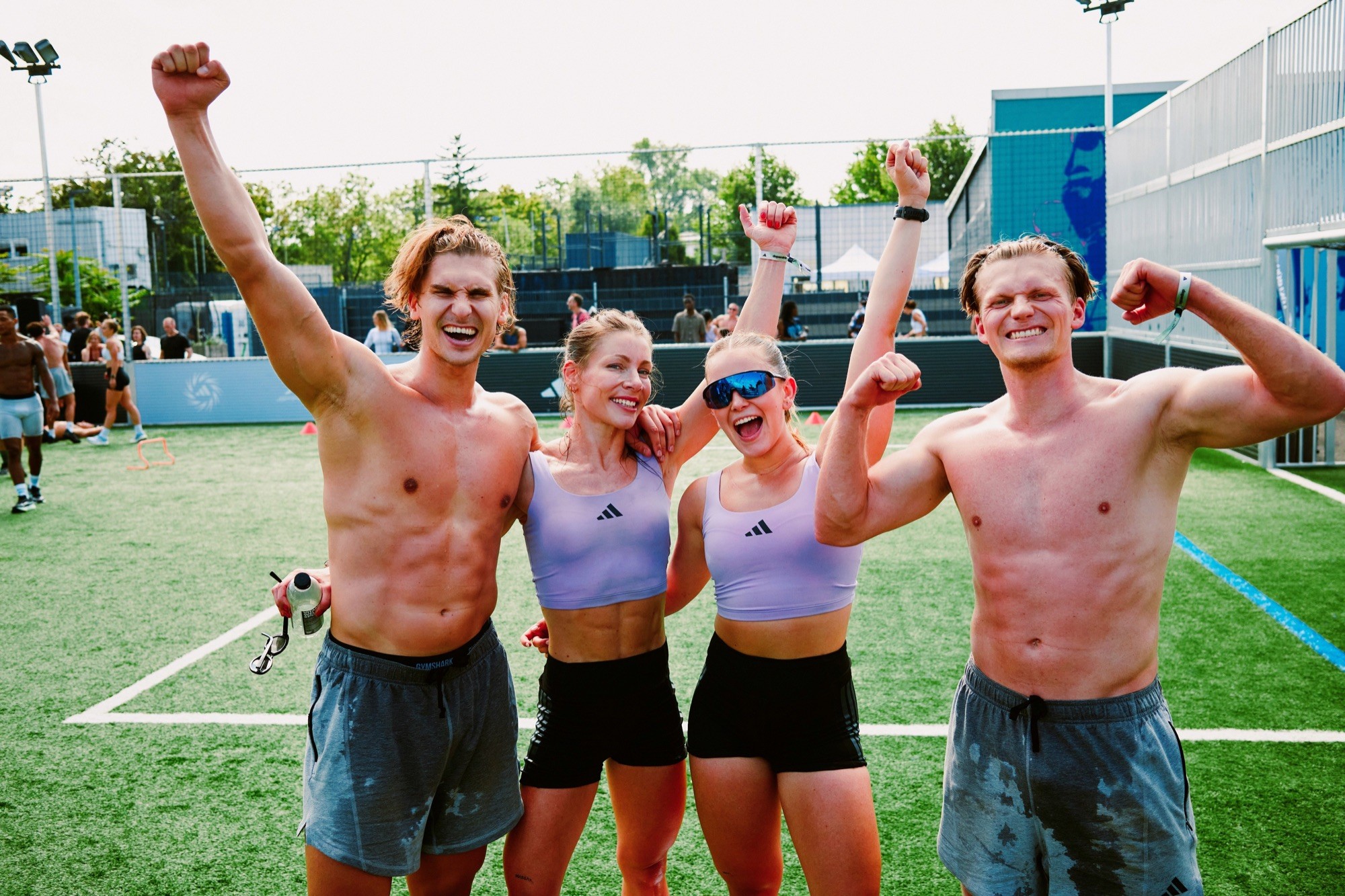 Four members celebrating together with raised arms after an outdoor session.