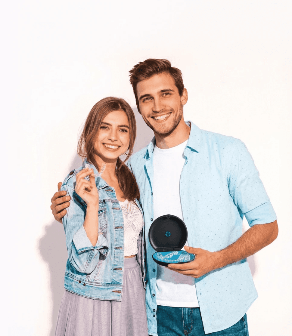 A woman smiles and holds invisalign clear aligners with a case, showcasing a certified invisalign provider at Bella Medical Centre