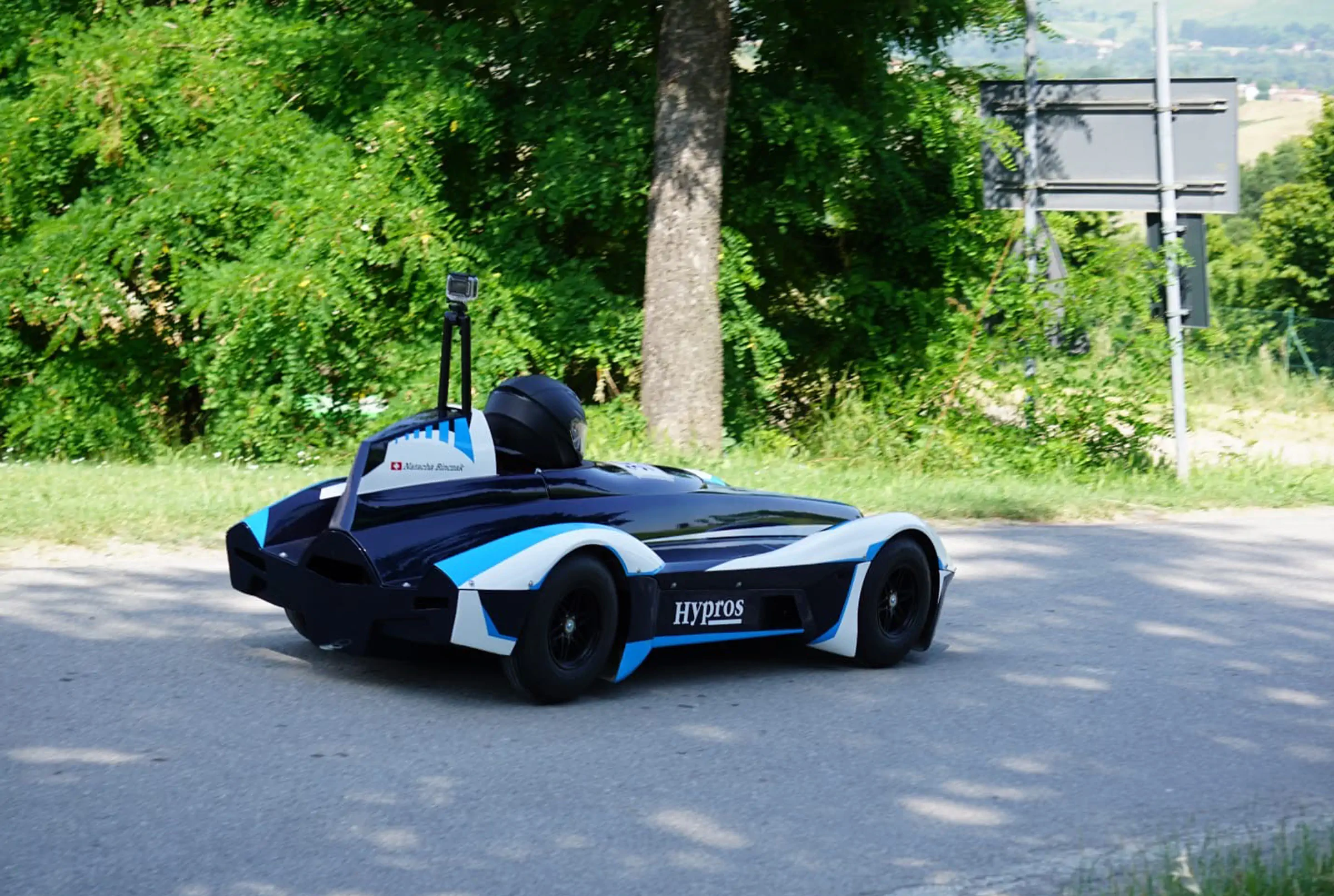 Caisse à savon Hypros sur la route de descente avec collines verdoyantes