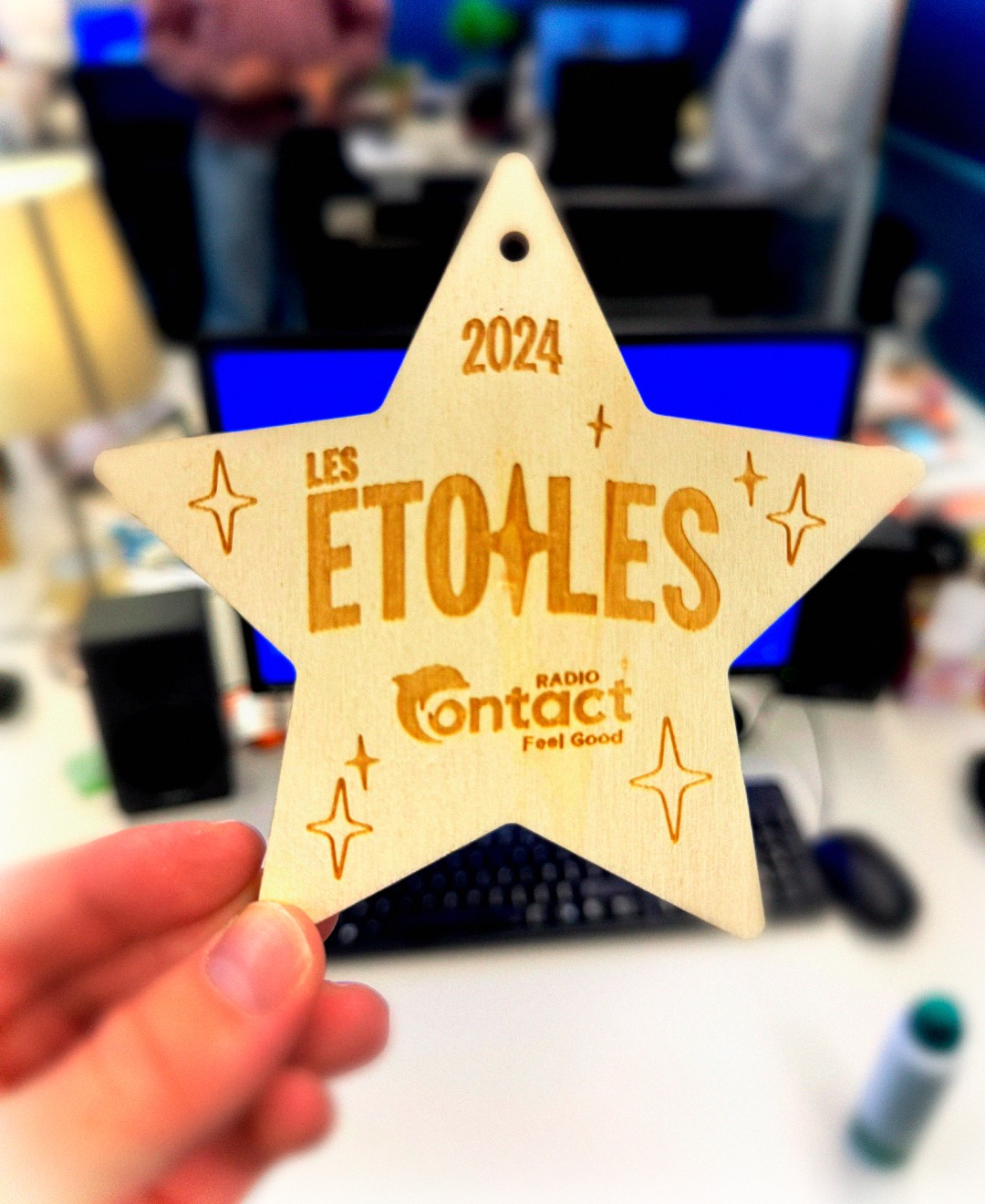 Modern home office setup with a monitor, ergonomic chair, keyboard, and indoor plants near a window with blinds.
