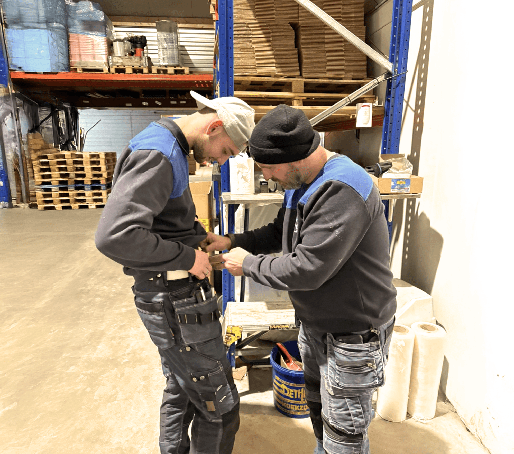 Een kind zit op een bank en aait zachtjes een zwarte hond in een met zonlicht gevulde kamer.