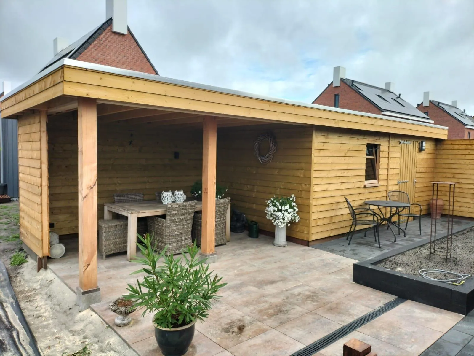 Houten veranda met overdekt terras en zitgedeelte aan woning in Gorredijk, Jubbega en Beetsterzwaag