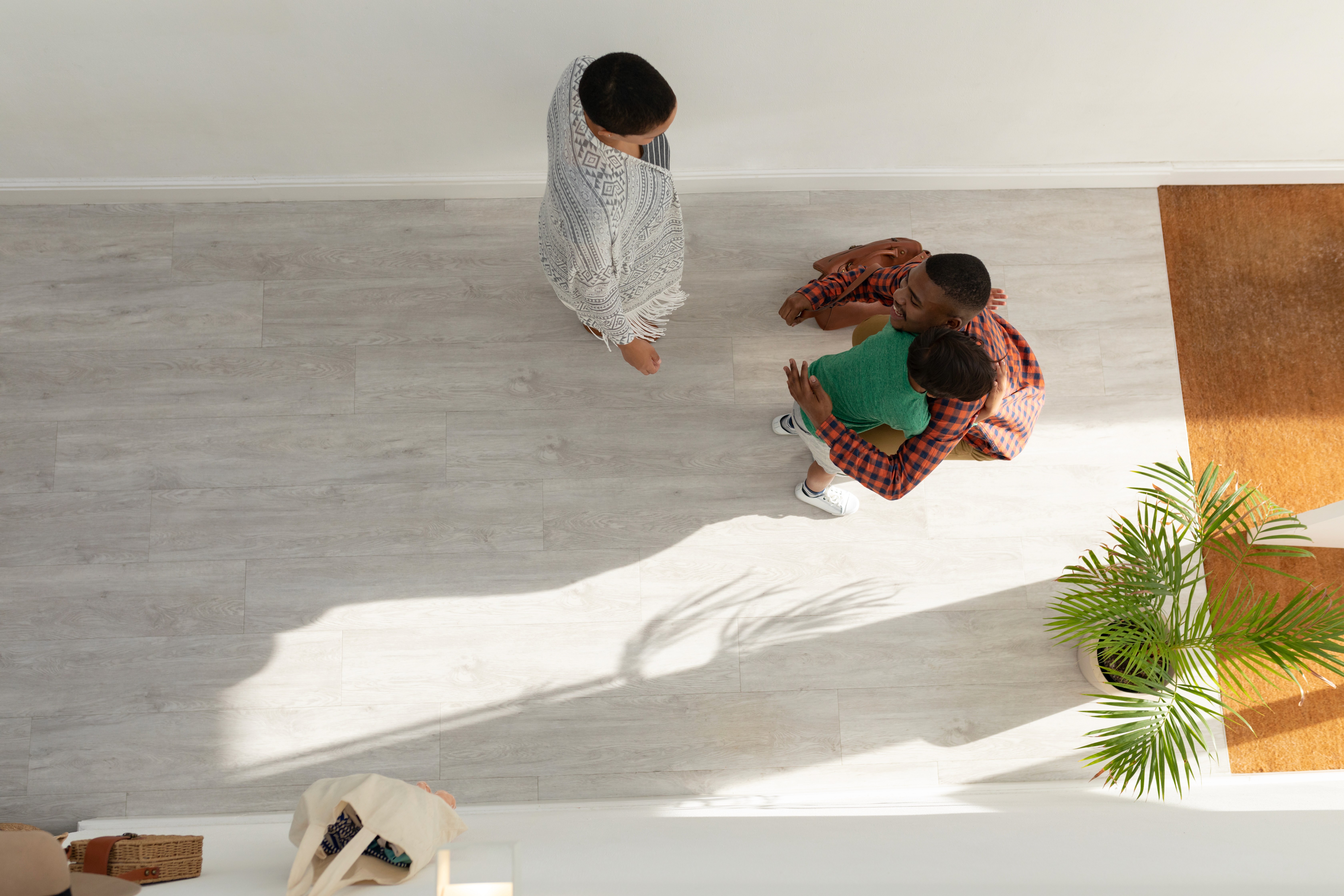 Family relaxing in a modern living space with light hybrid flooring, ideal for busy Australian homes needing durable, low-maintenance, family-friendly floors.