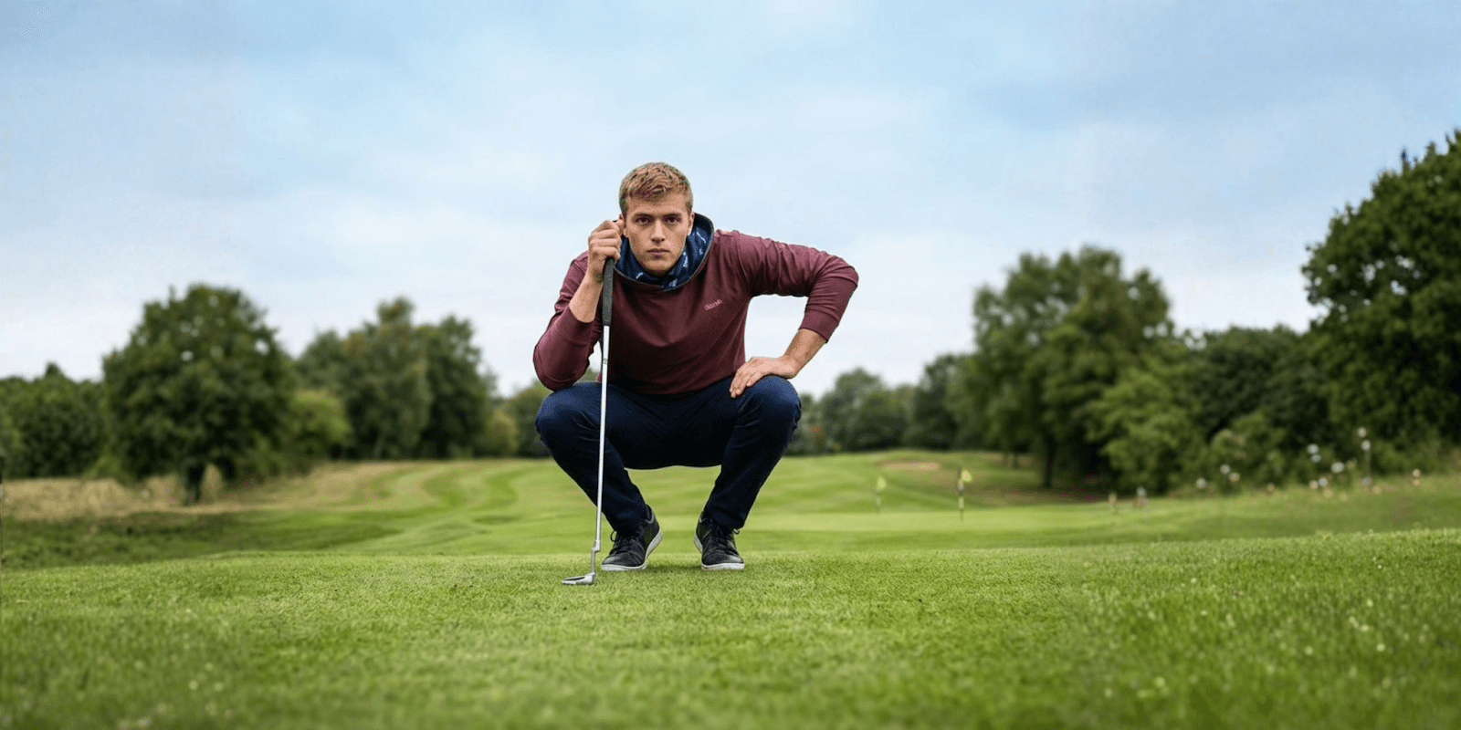 Professional golfer analyzing his putt, showcasing Caddie Couture's modern golf apparel designed for performance and individuality on the course.