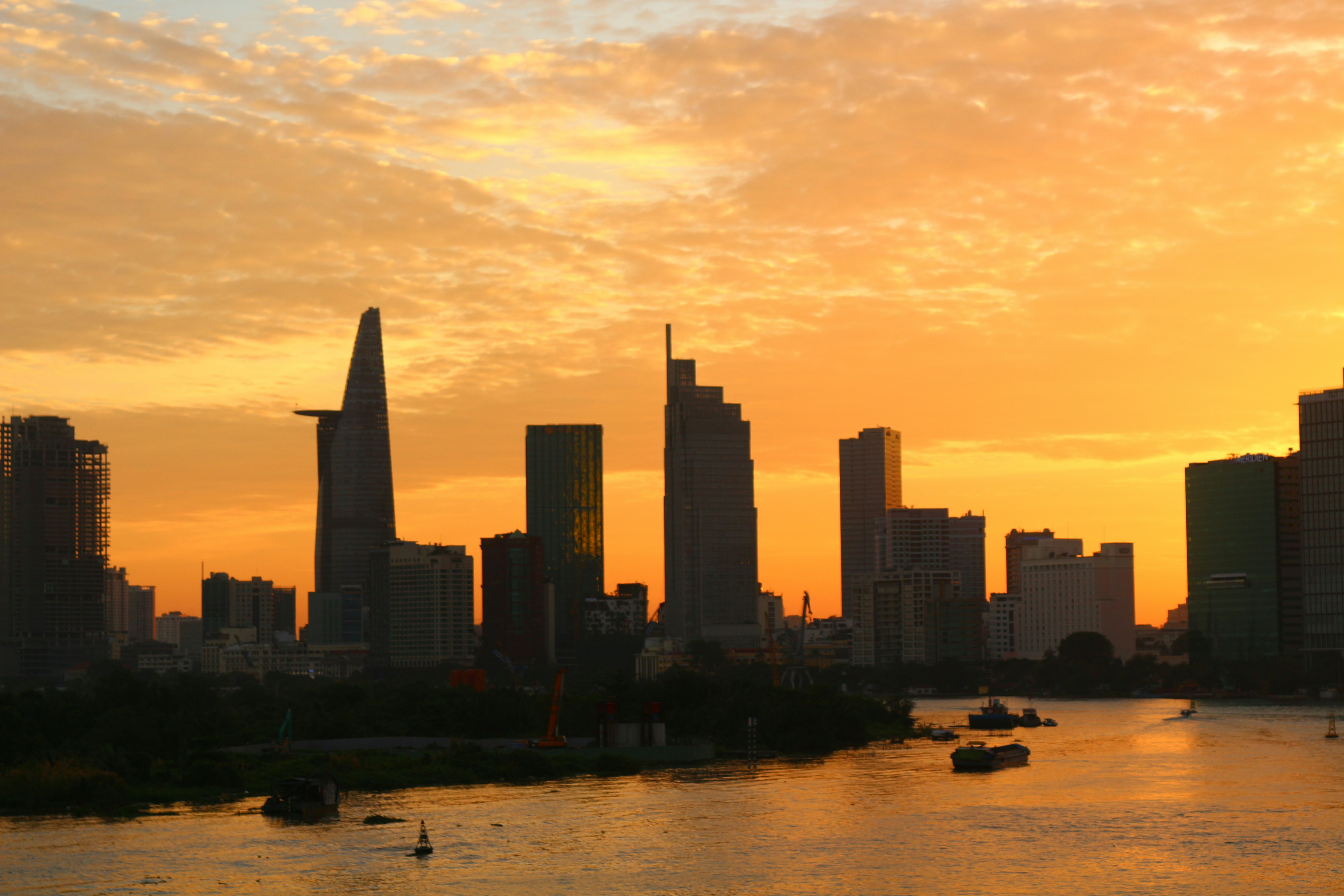 a sunset view of a city with boats in the water