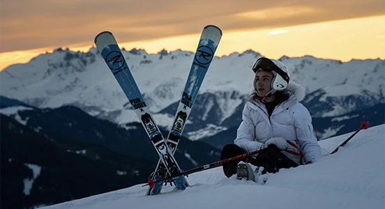 Femme assise avec skis loués sur jam