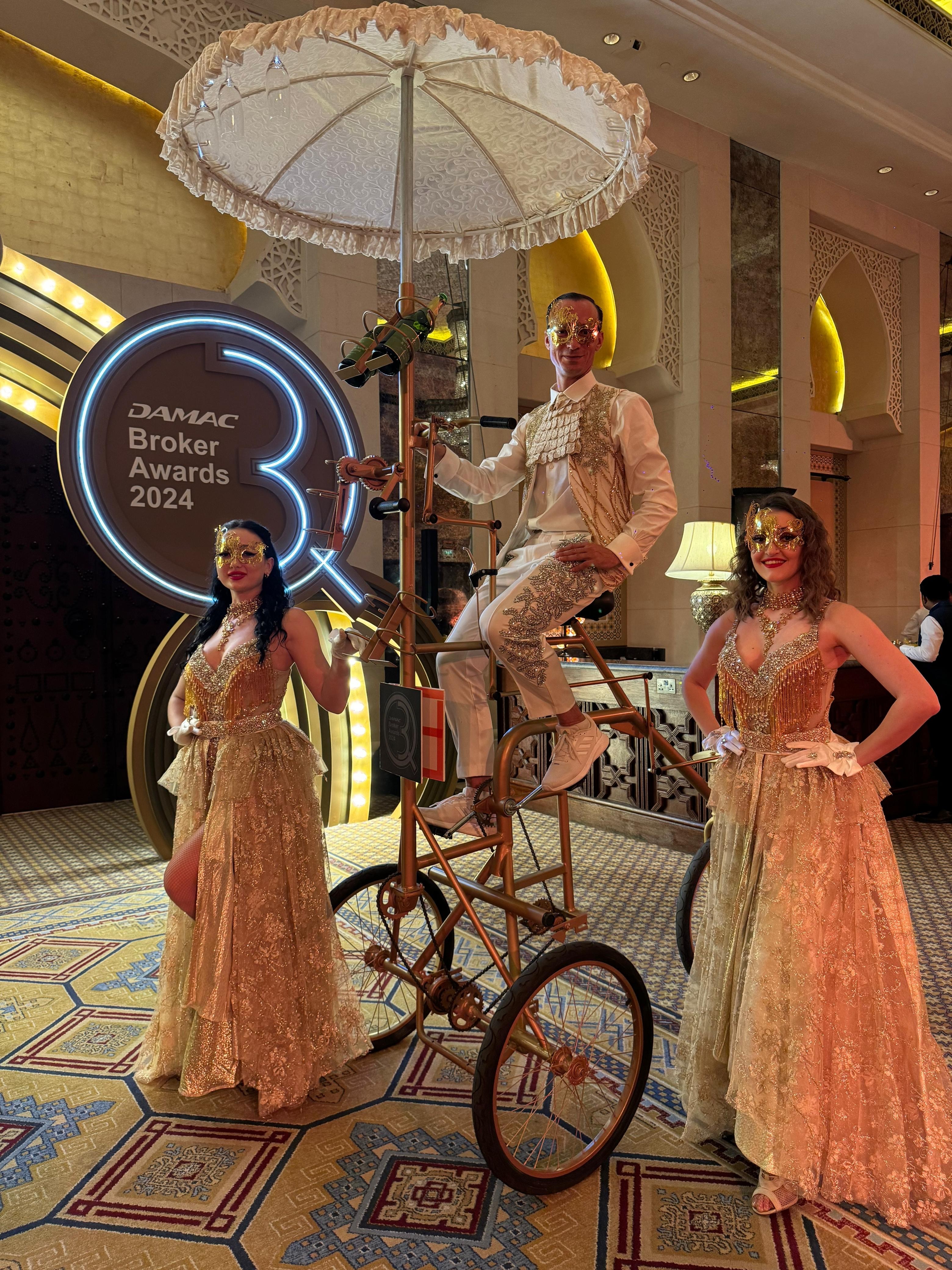 Vintage tricycle roaming act with masked gold costume performers at DAMAC Broker Awards 2024