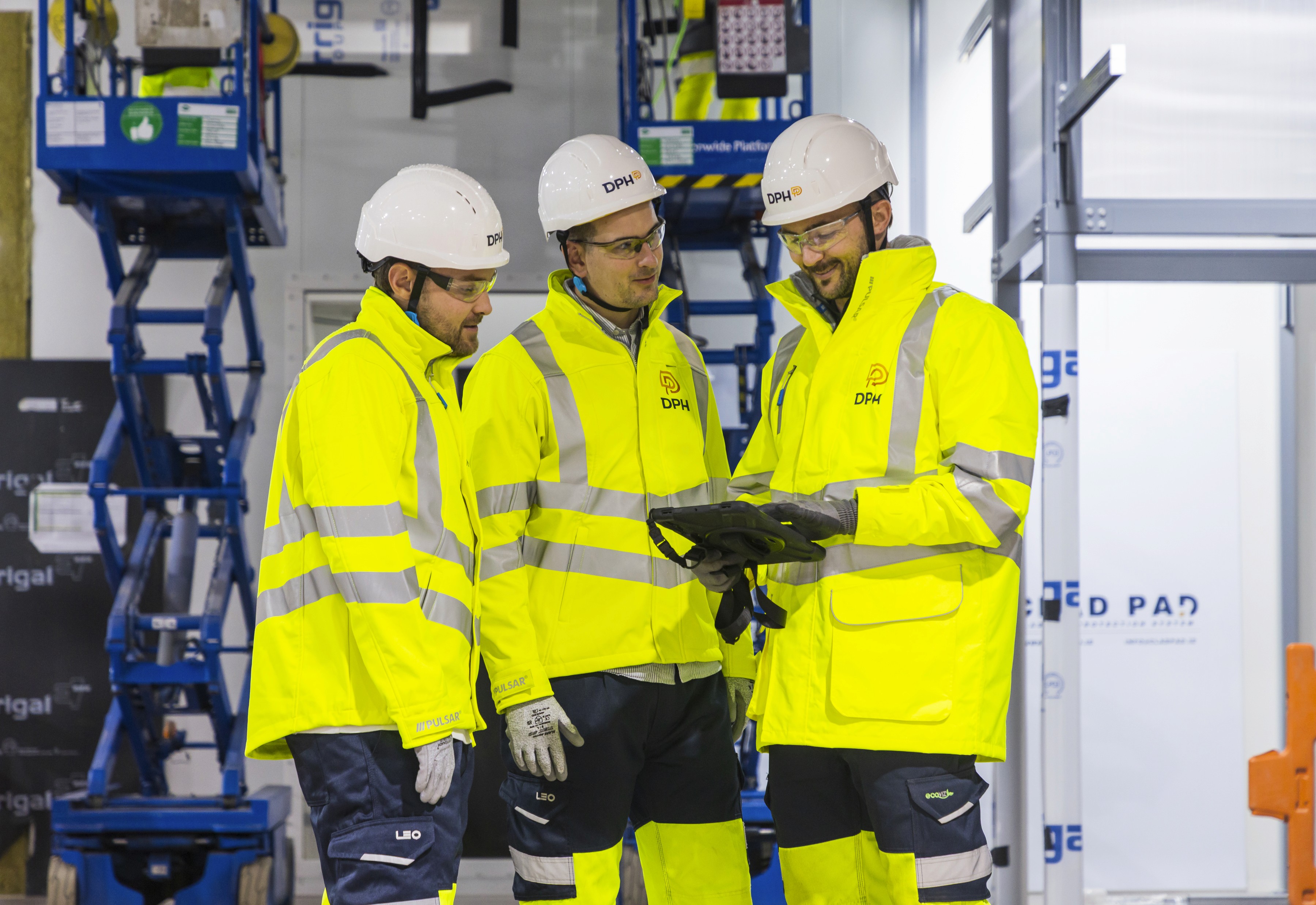 Rooftop garden with trees and plants, overlooking a cityscape at sunset with a tall building in the background