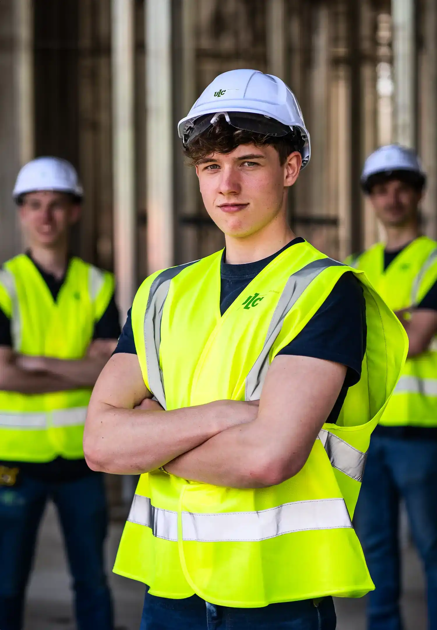 Drie collega's poseren voor bedrijfsfotografie in een industriële omgeving