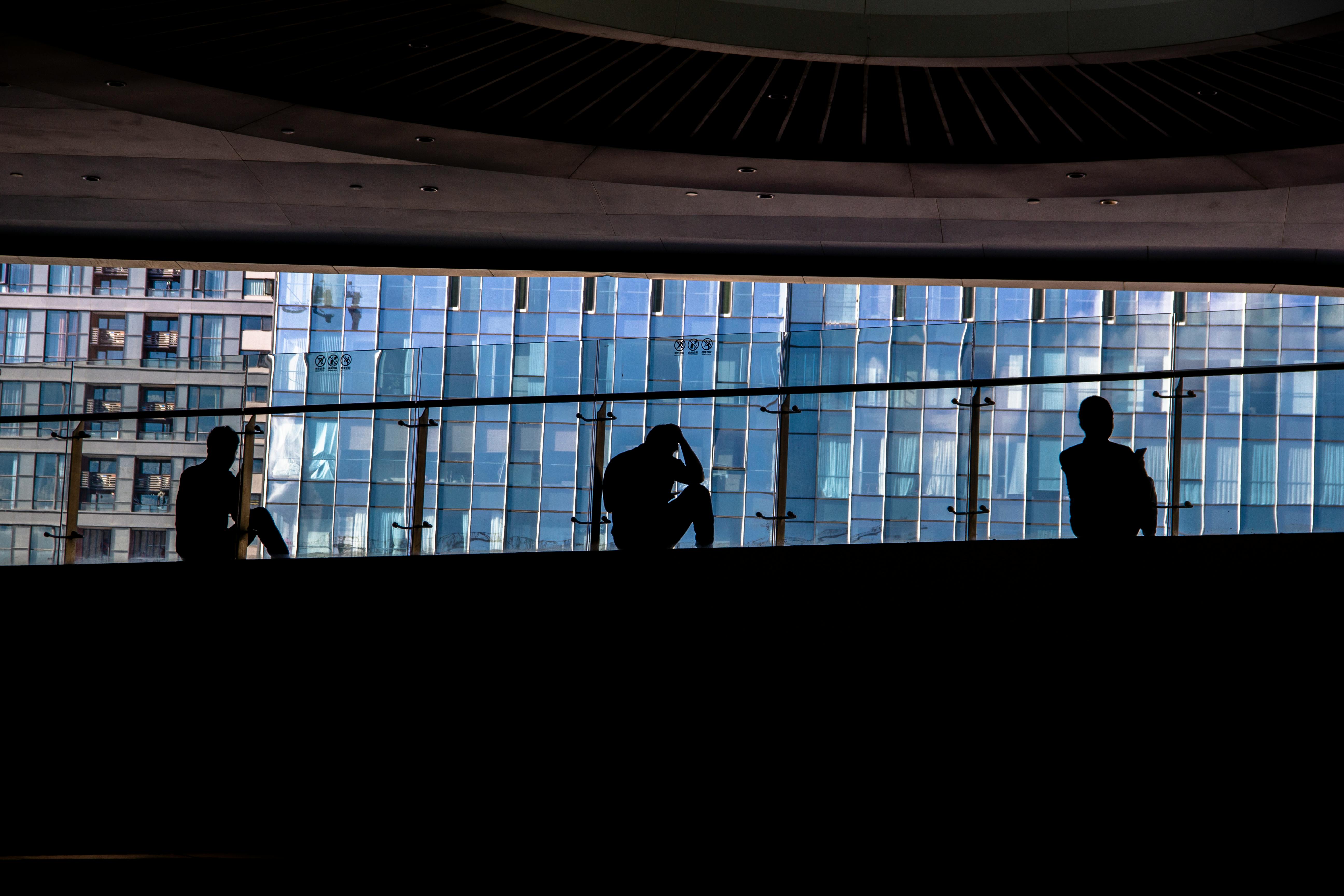 Silhouette di persone in uno spazio urbano moderno, simbolo dell’incertezza professionale e della paura di diventare obsoleti nel contesto del lavoro del 2026.