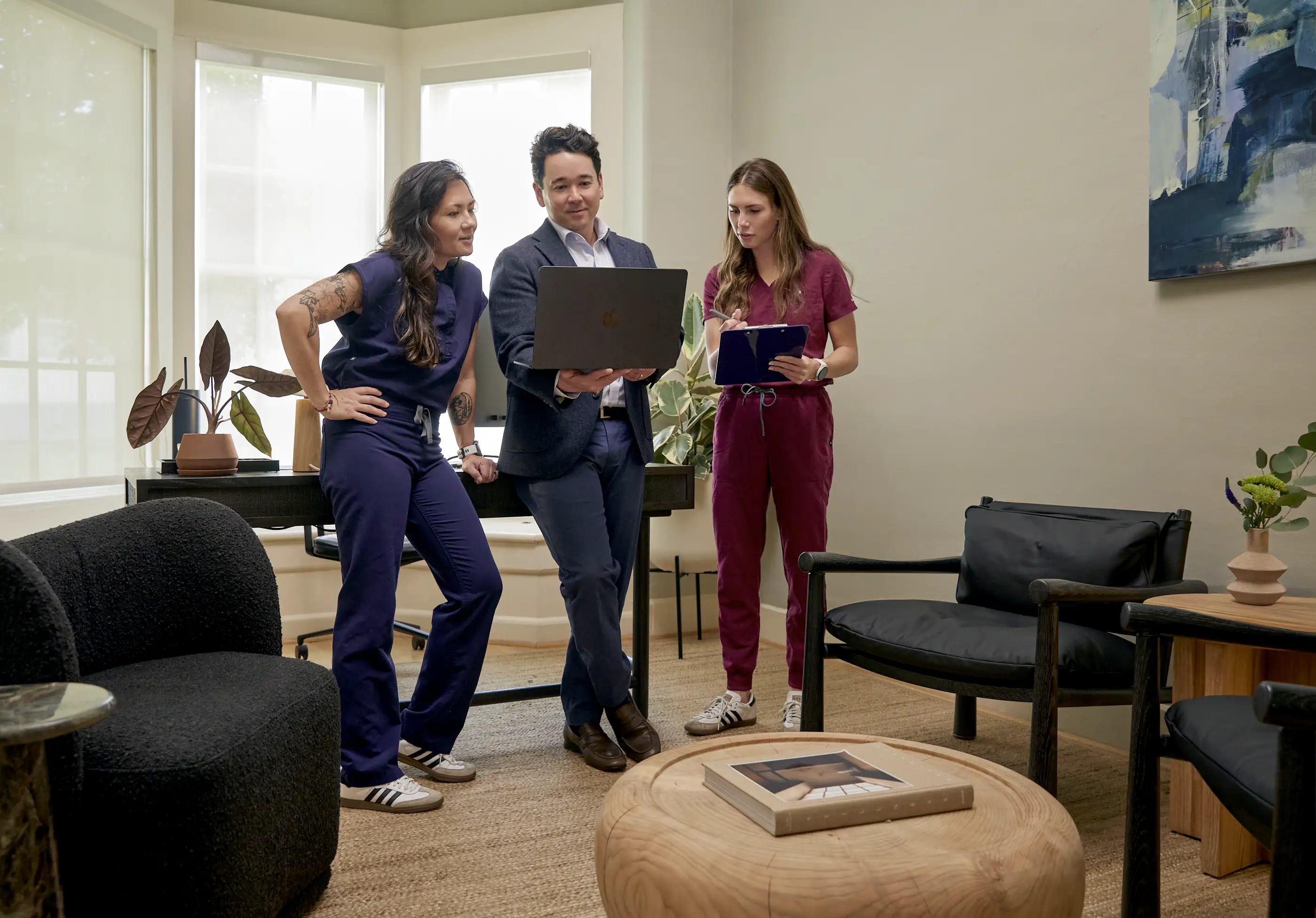 Three BlueWave Medicine team members reviewing a patient care plan together in a consultation room.