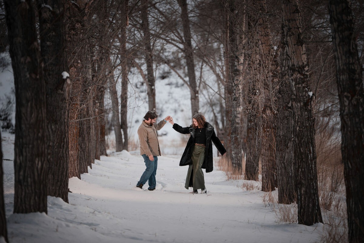 Couple standing beneath brilliant orange aspen leaves in Snowmass