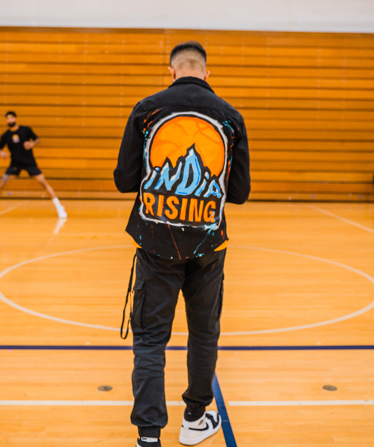 The back of a man wearing a jacket featuring the logo