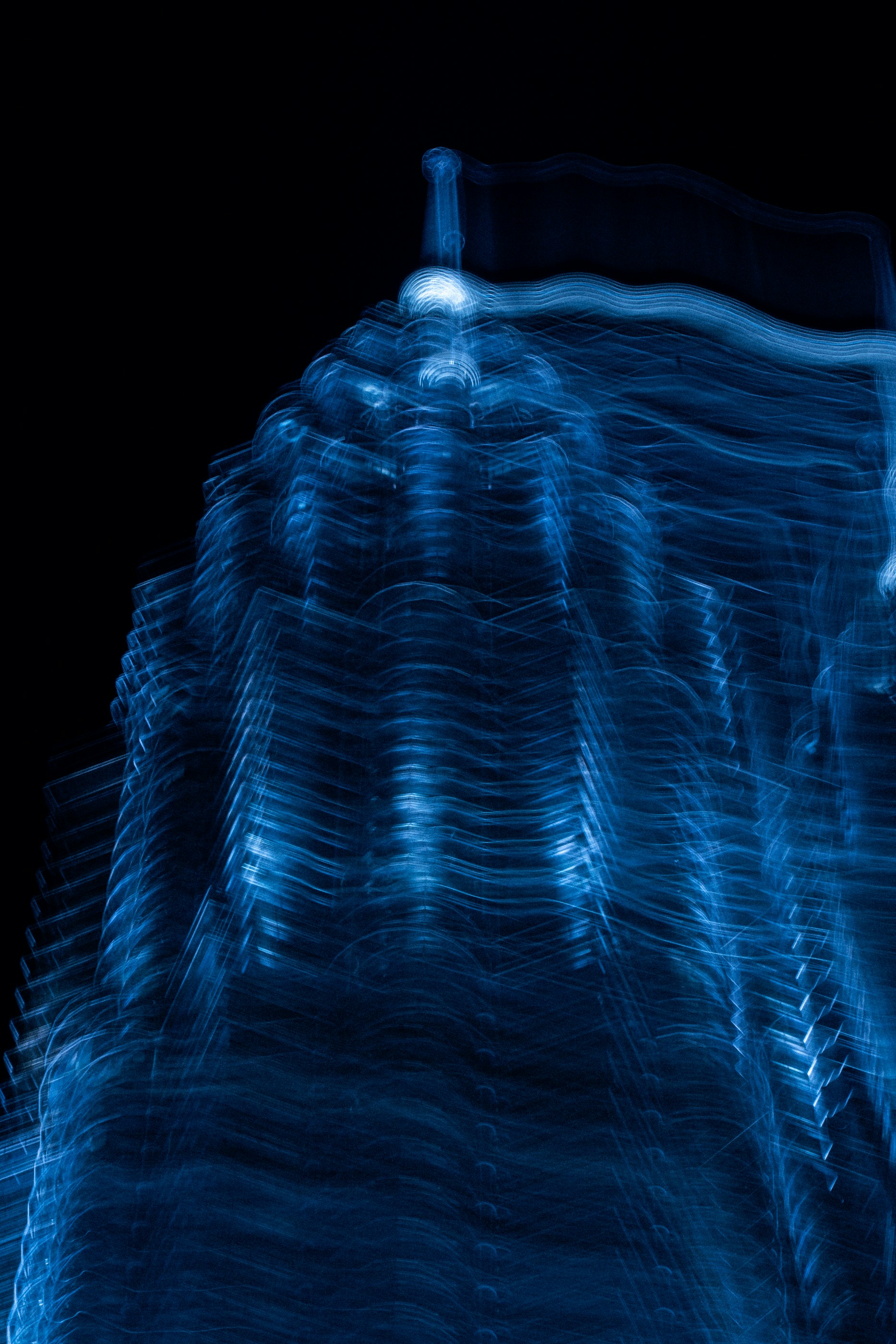 A blurred blue structure against a black background.