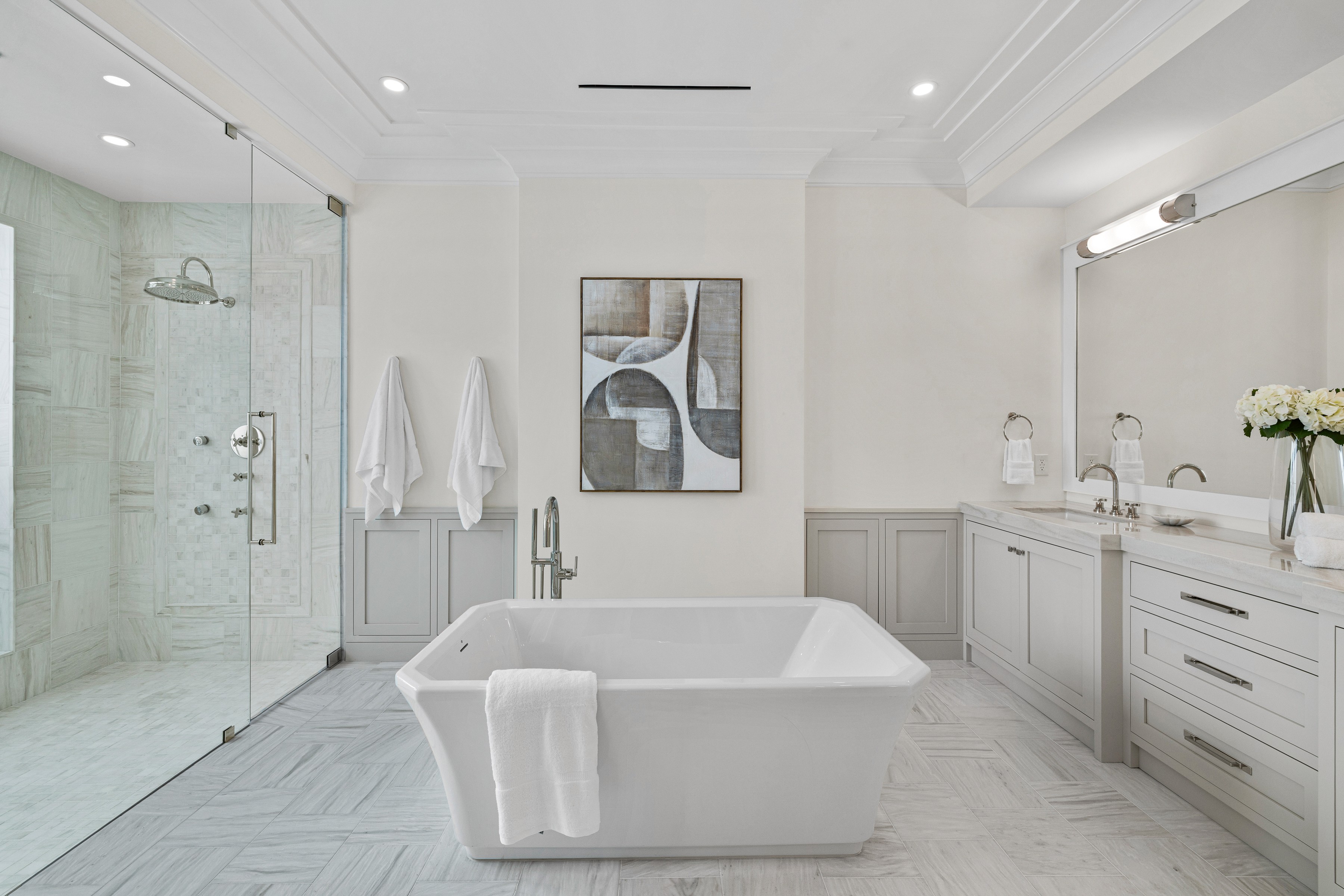 a luxurious white bathroom with a tub in the center of the frame