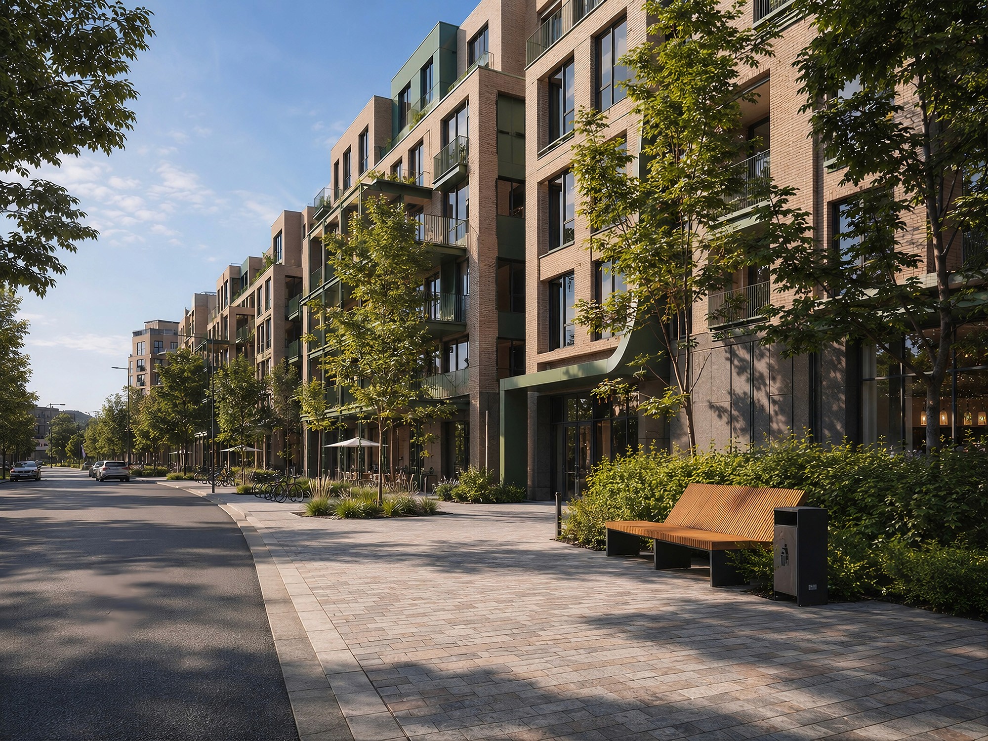 A wide, paved sidewalk with a wooden bench running alongside a modern brick apartment building with green balconies and street trees.