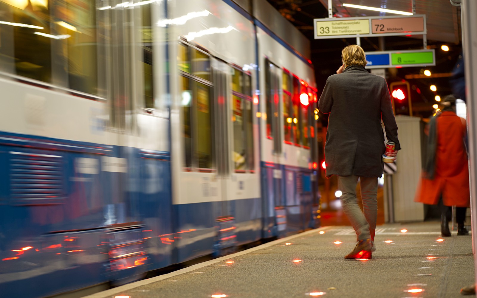 Passengers on platform at Zurich Central for airport train transfer.
