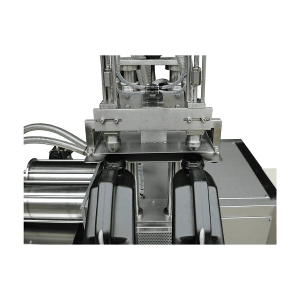 A close-up of the 2-head volumetric bottle filler, highlighting the filling mechanism for a Malaysian factory.