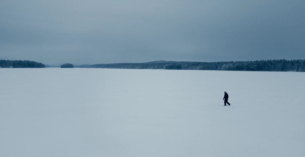 A lone figure walking through a snowy landscape