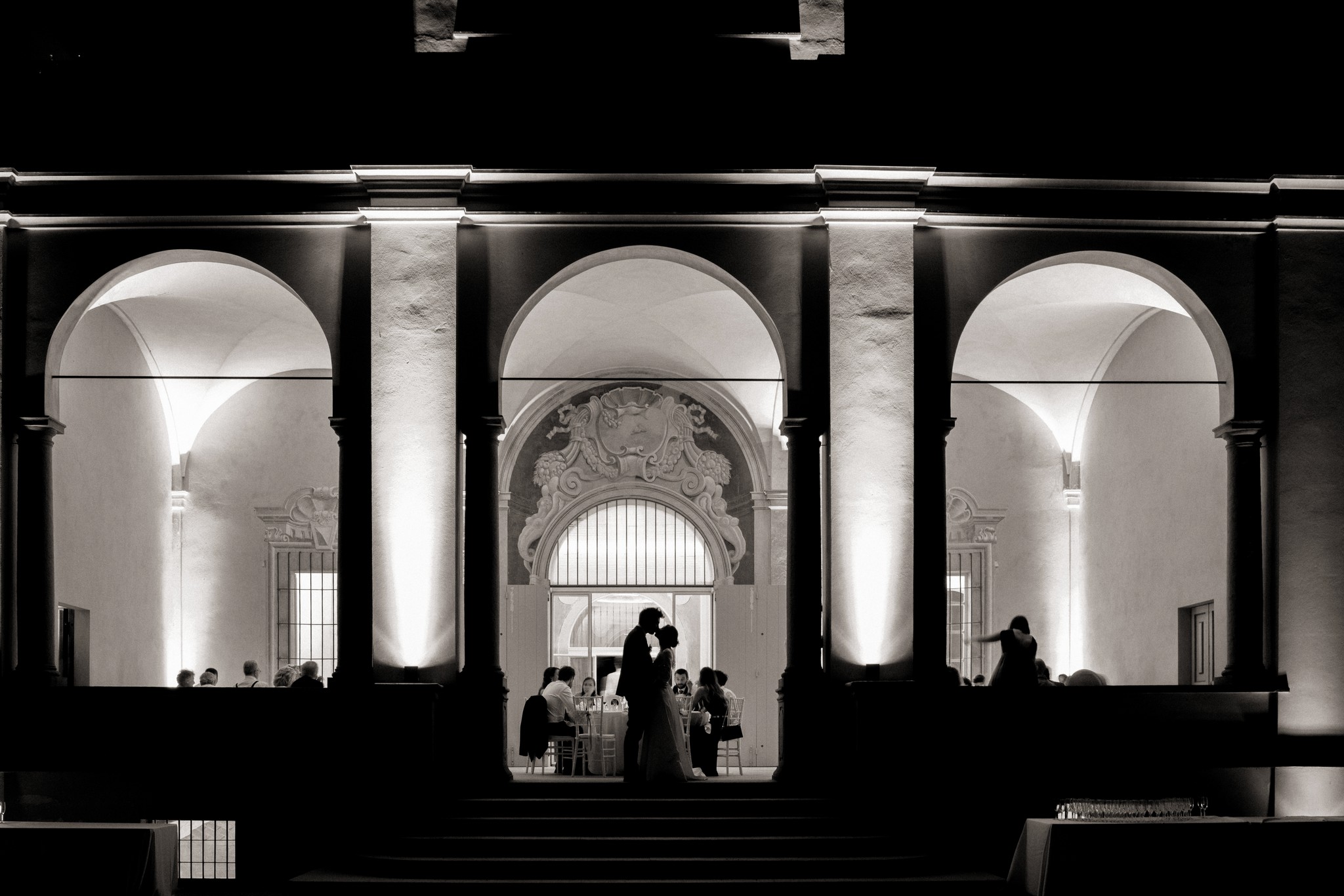 Sposi illuminati sotto gli archi di Villa Peroni Riva, momento solenne dopo la cerimonia matrimoniale