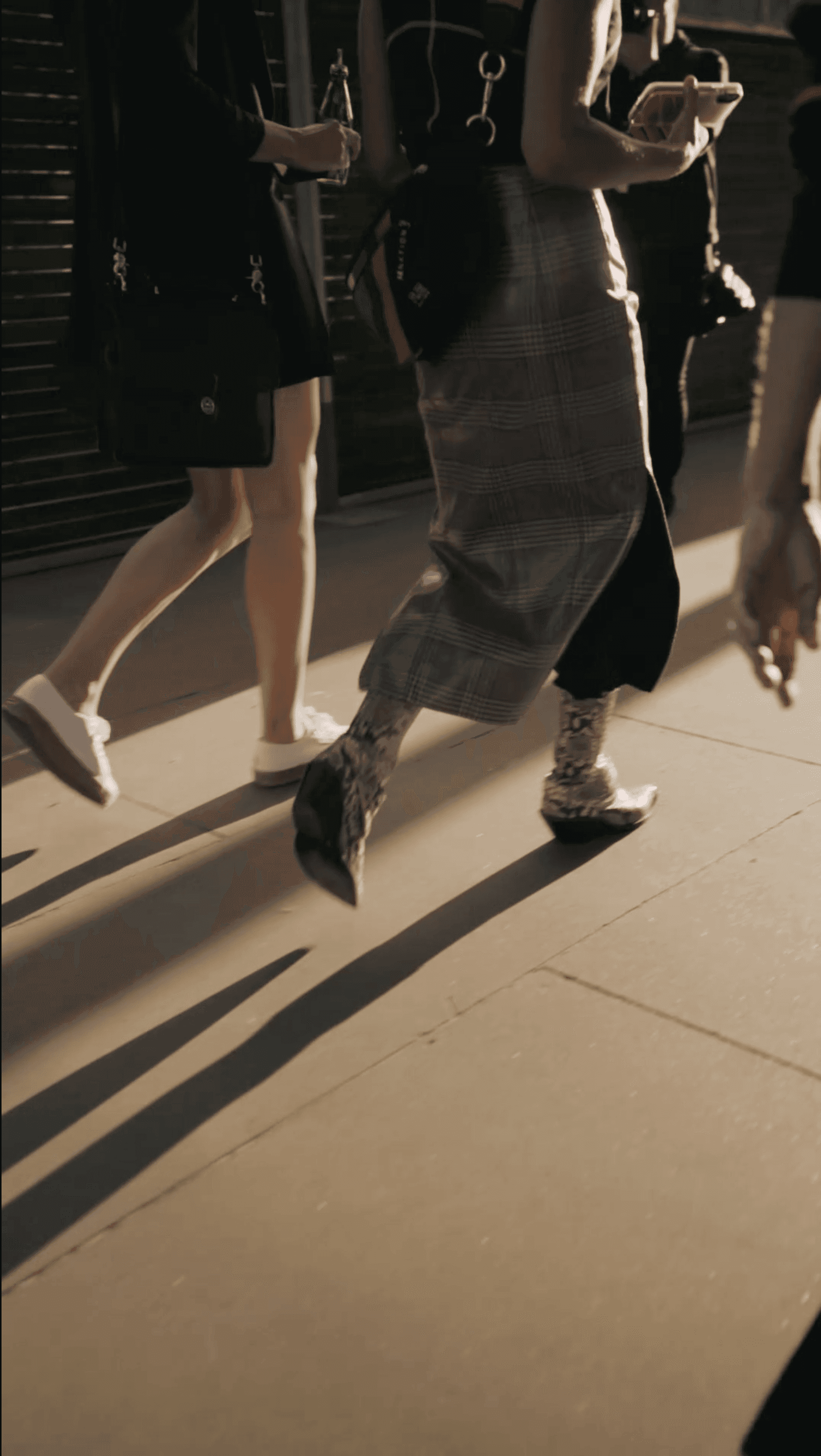 Low angle view of people's legs and feet walking on a reflective floor