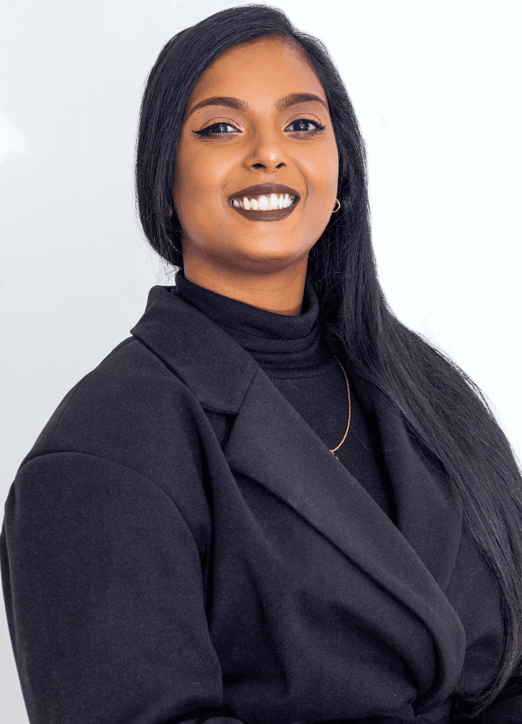 A man with glasses and a beard is looking directly at the camera, seated in a cozy, dimly lit café.