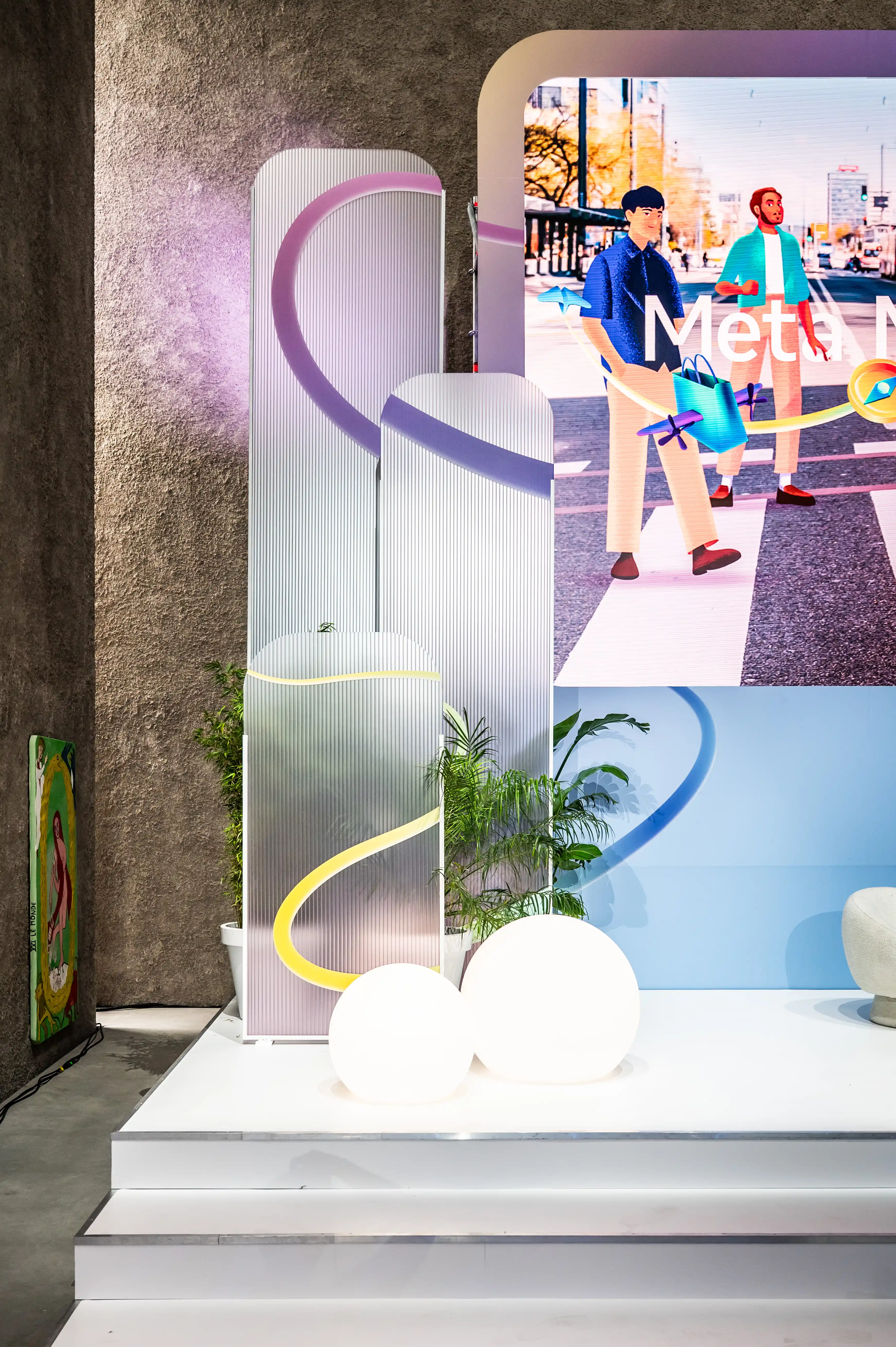 Display with ribbed acrylic panels, glowing spheres, palms and Meta campaign screens on white steps.