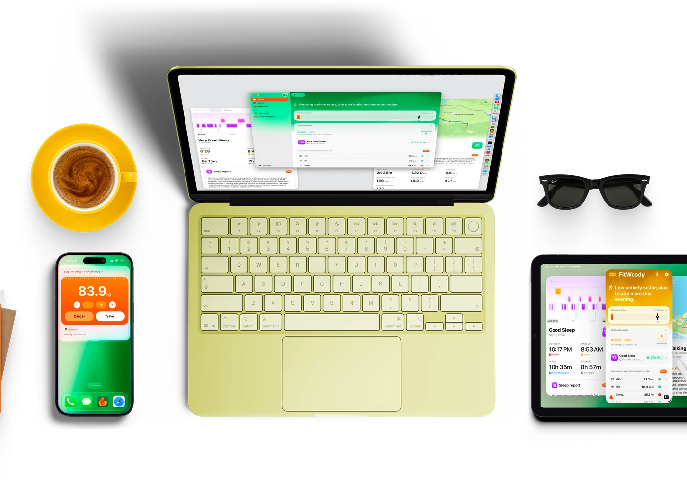 iPhone, iPad y Apple Watch con FitWoody entre objetos de un día normal: gafas de sol, un cuaderno, un café y unos AirPods