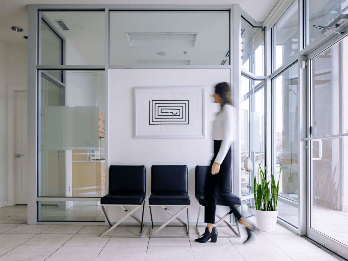 Alpha Dental office waiting area with chairs and artwork.