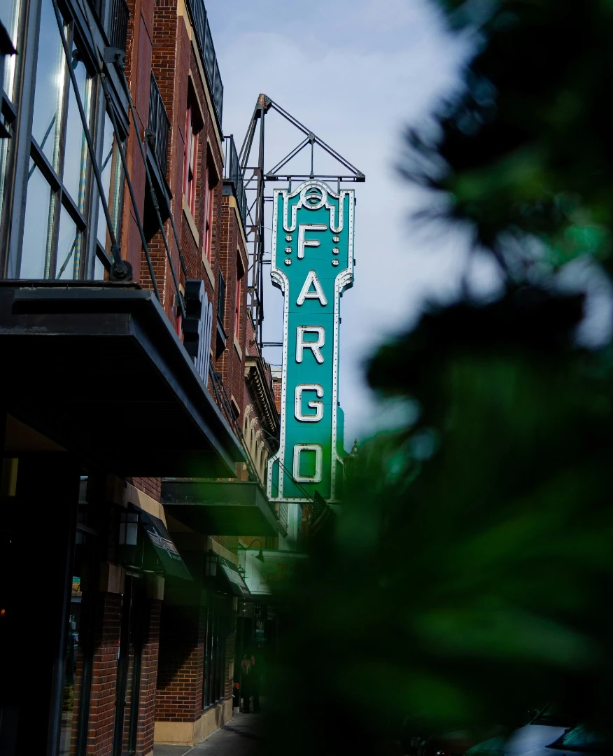 A large green Fargo sign hanging from the side of a building, Fargo, ND.