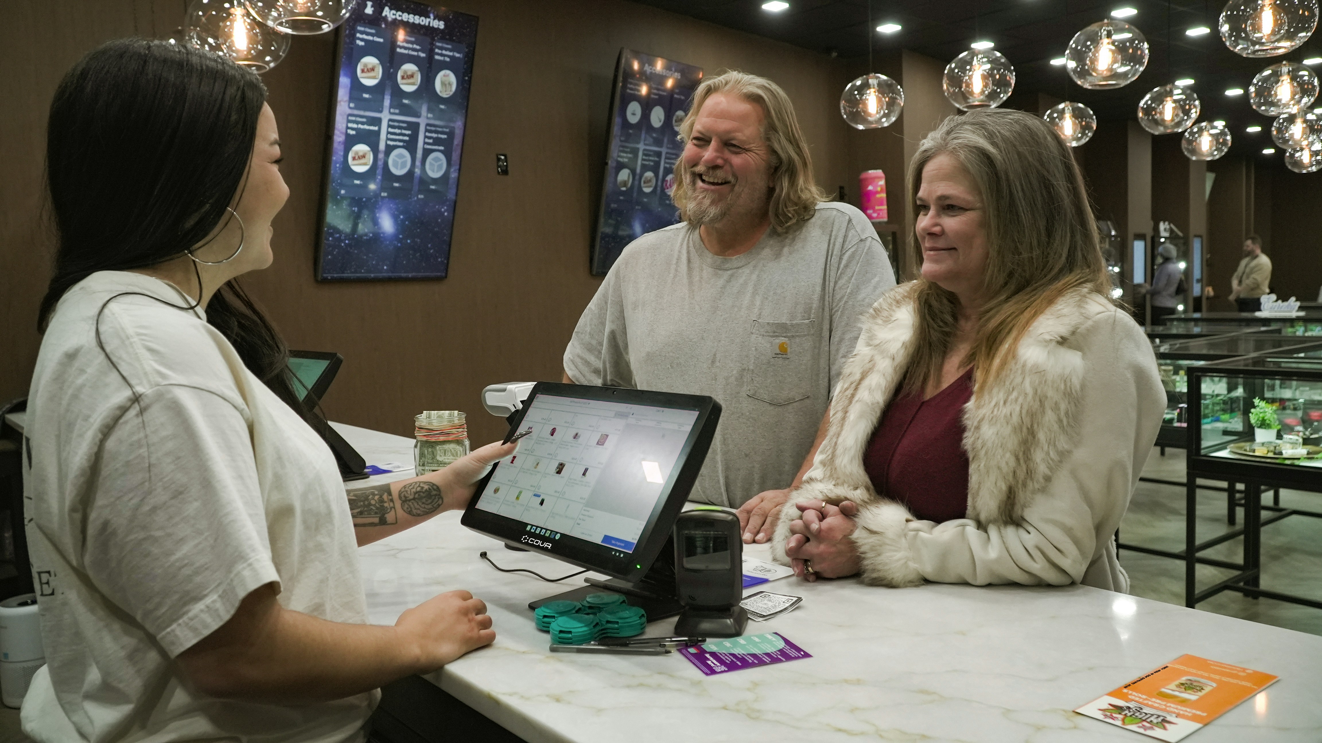 Customers interacting with a cashier at a counter.