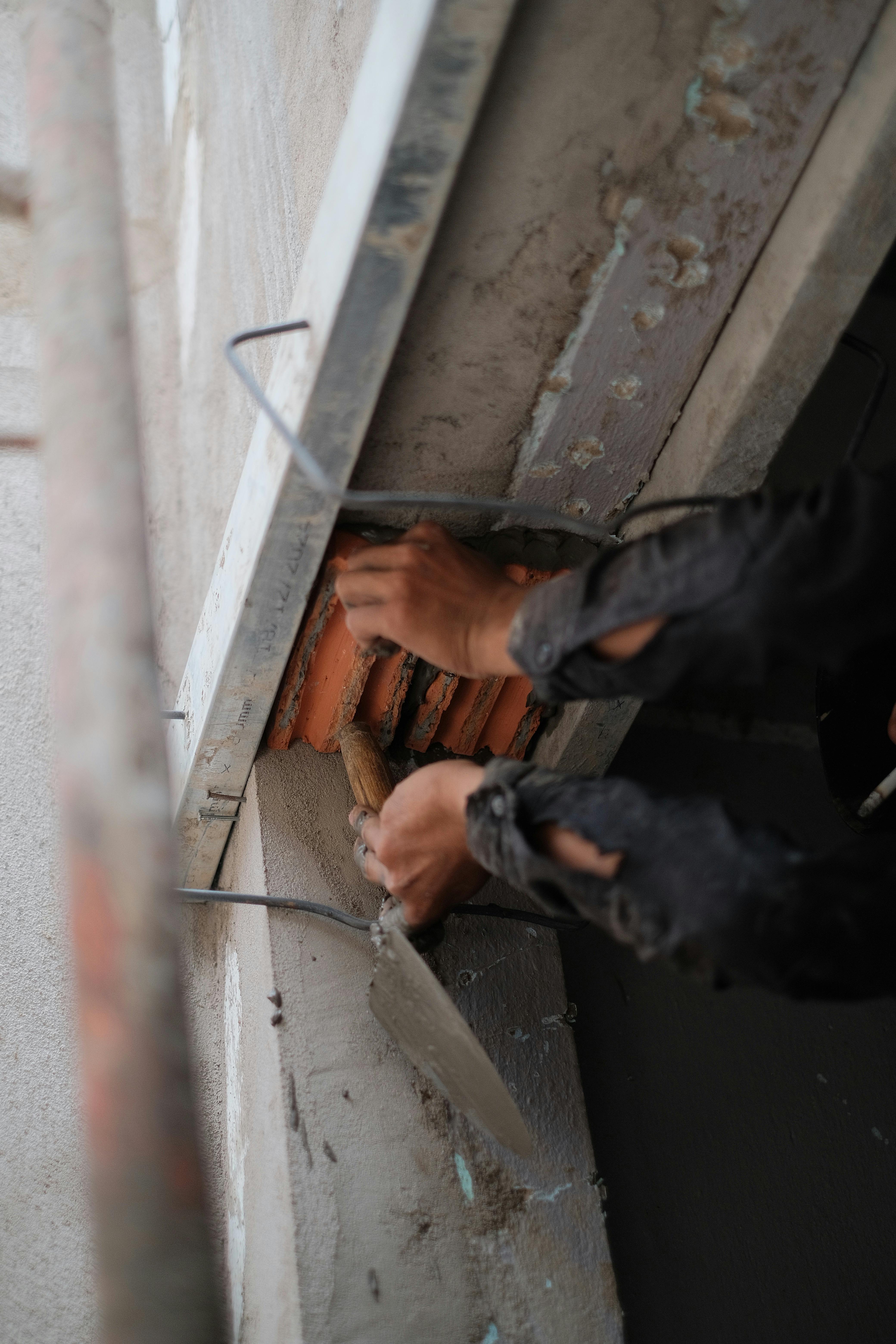 Modern living room with abstract art, beige sectional sofa, indoor plants, and large windows.
