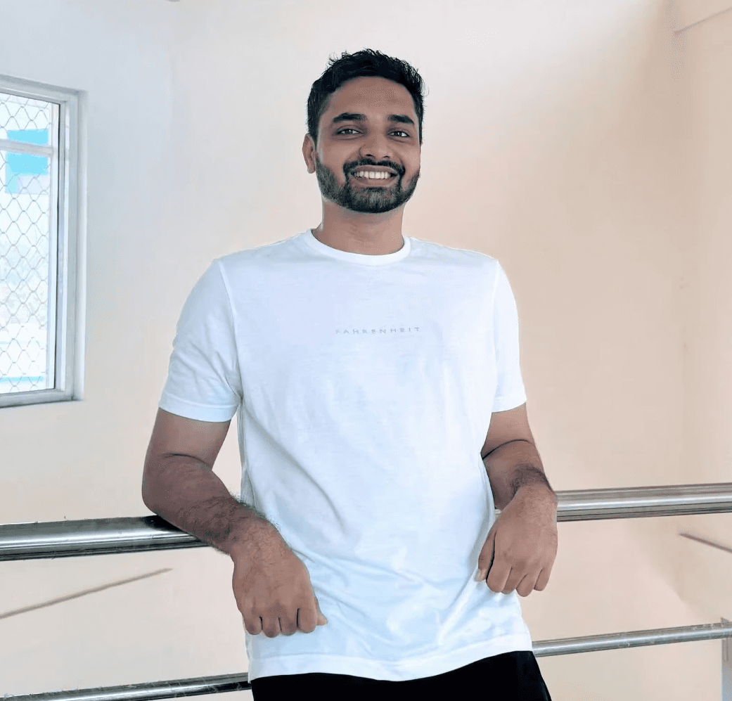 man sitting near gray steel roller shutters during daytime