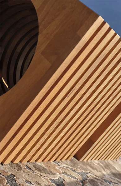 Close-up detail of luxury outdoor side table in solid Iroko wood, showing the precision-crafted square panels and structural rods of the Layer design – refined craftsmanship and material texture for high-end furniture.
