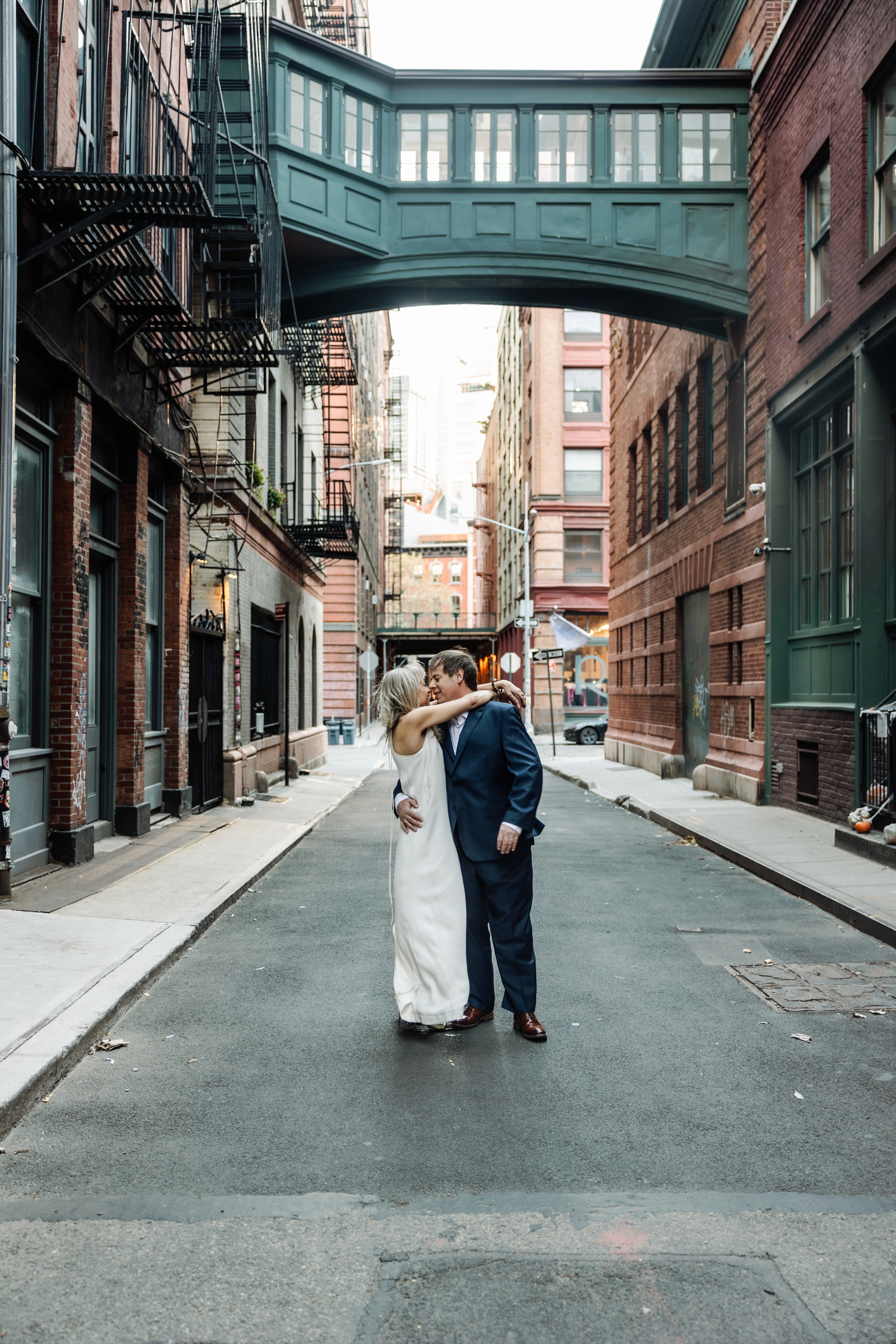 6:13 PMNewly engaged couple sitting on a stoop in the West Village, NYC bathed in warm golden hour light — romantic, candid golden hour engagement photography by Lizz Spano Photography, New York City engagement photographer.
