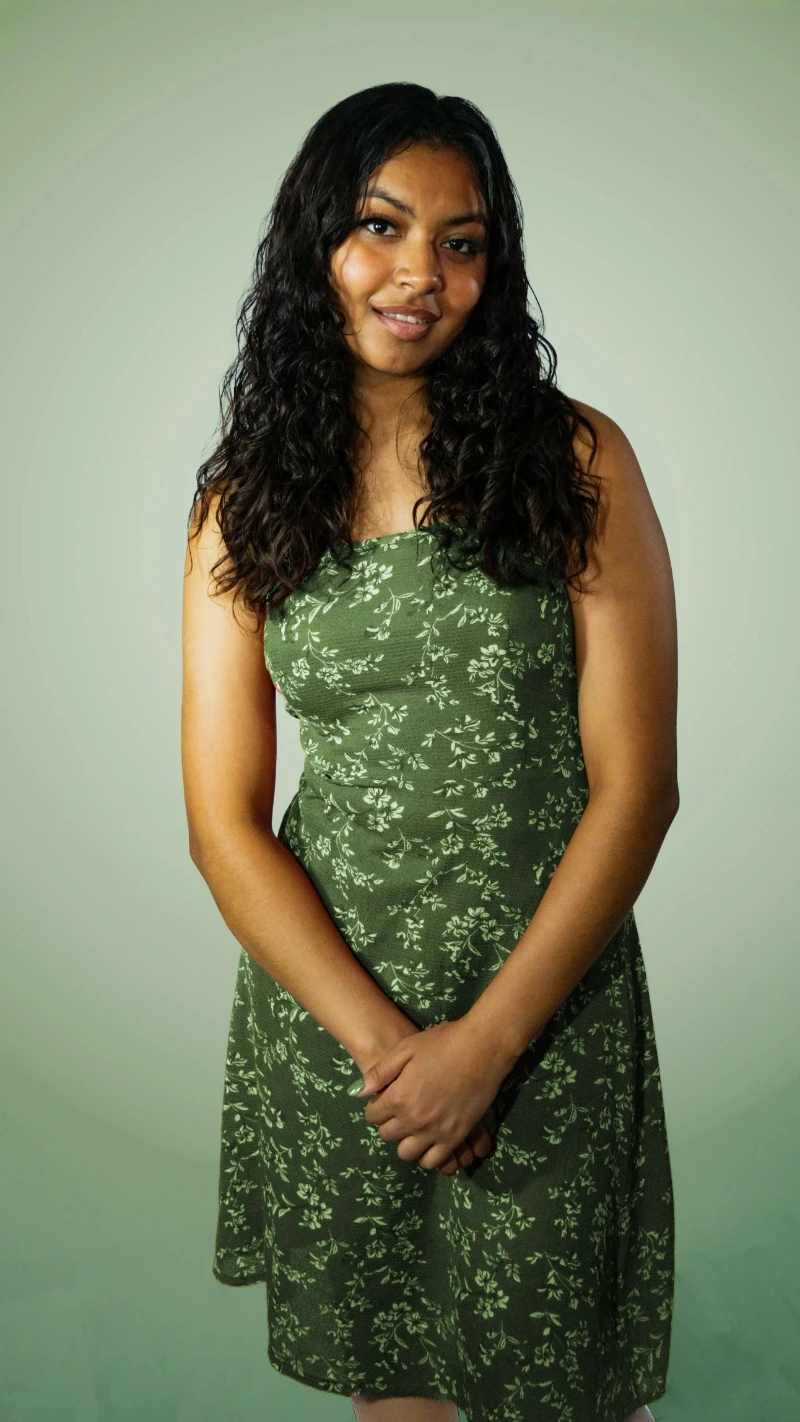 a man in a black hoodie standing in front of a tree