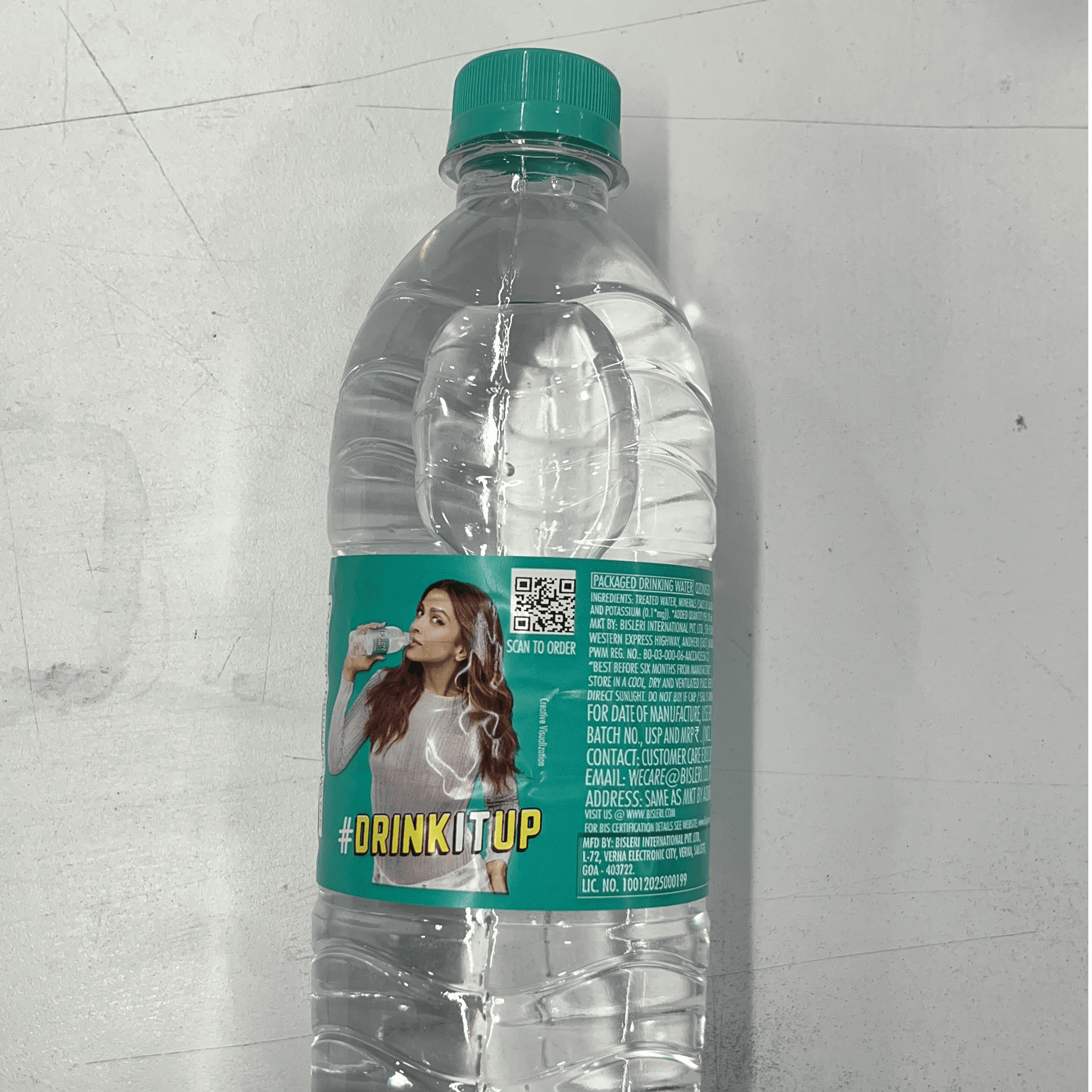 Woman in red outfit poses by a red telephone booth.