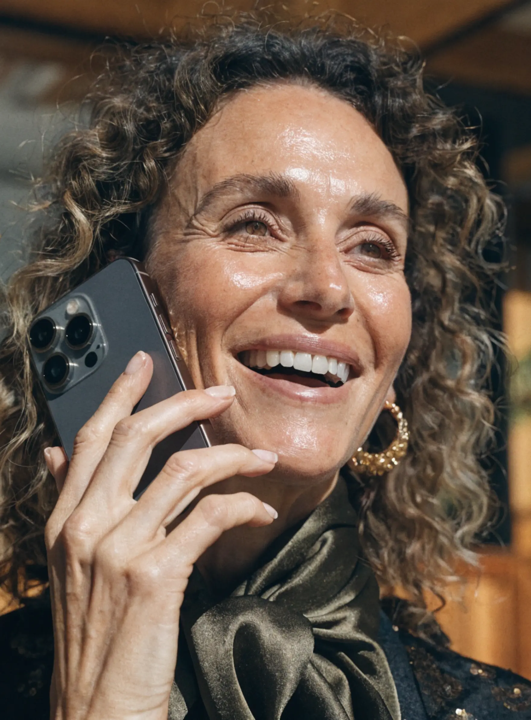 Une femme souriante qui téléphone à ses collaborateurs pour gérer sa franchise