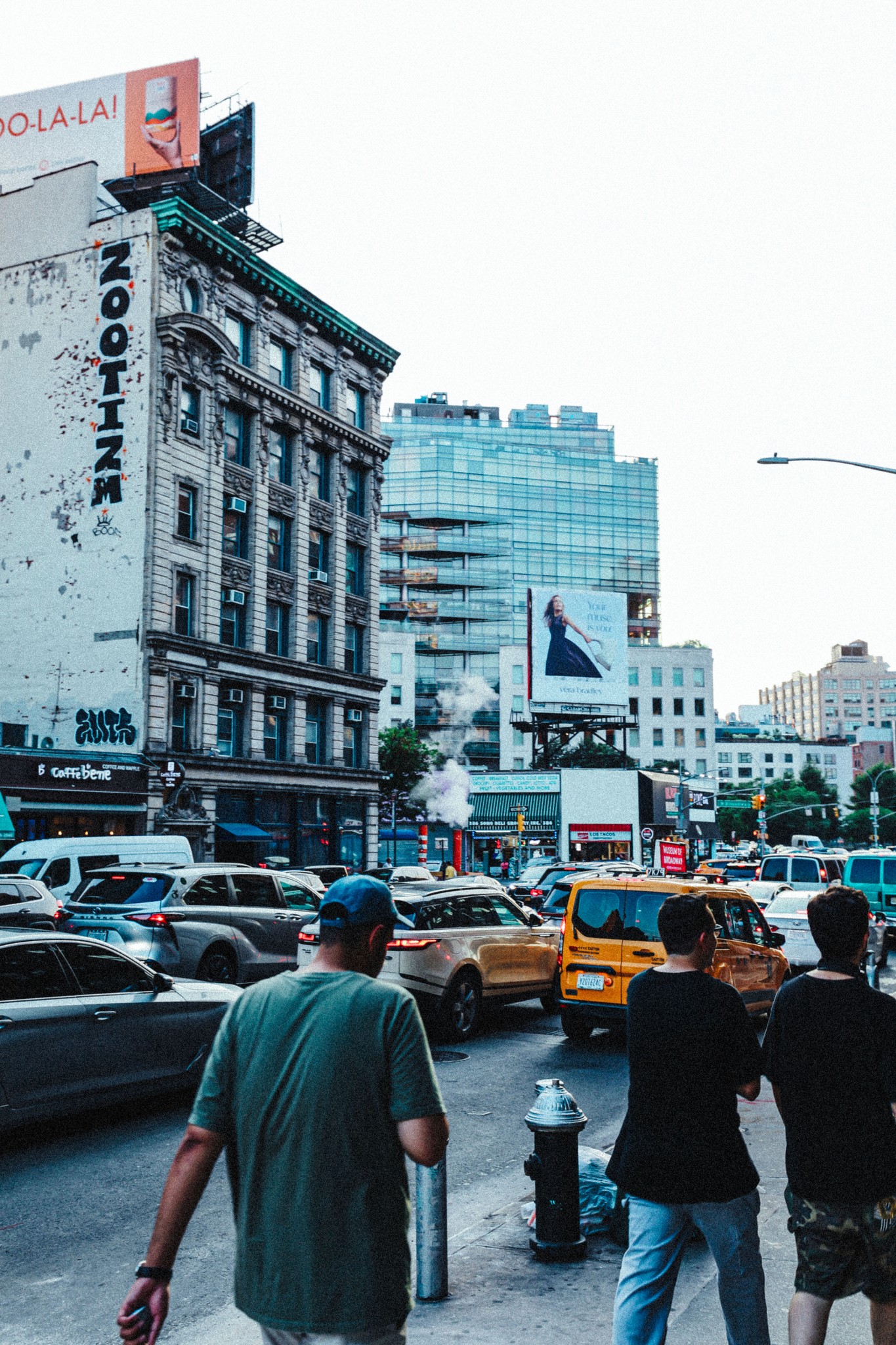 Black and white photo of two people looking at a computer screen with papers on wall