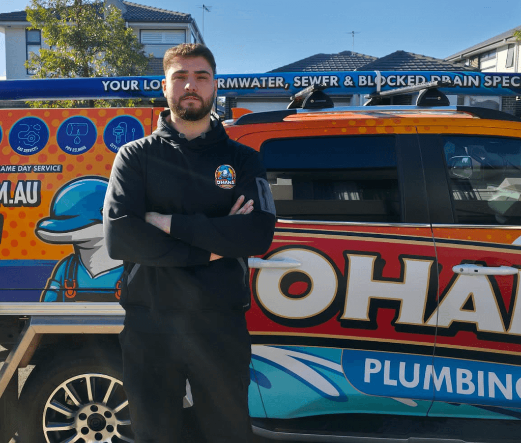 Ben from Ohana plumbing Sydney doing drainage cleaning in front of his vehicle
